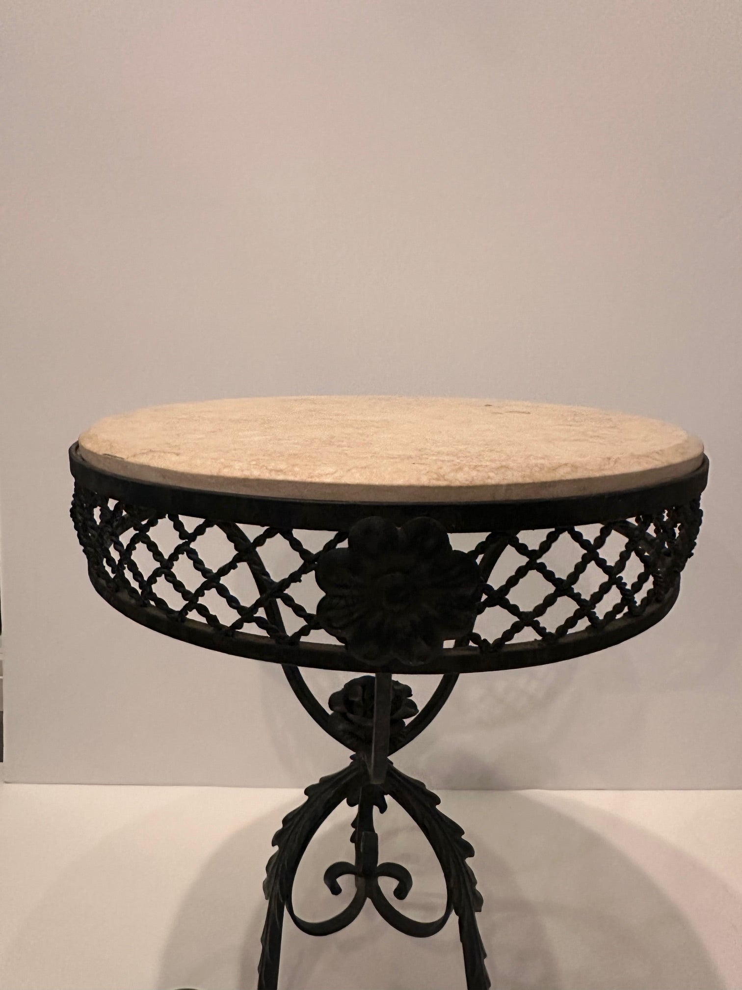 Very pretty ornate hand wrought iron round side or end table having curlicues and flowers with off white marble top.