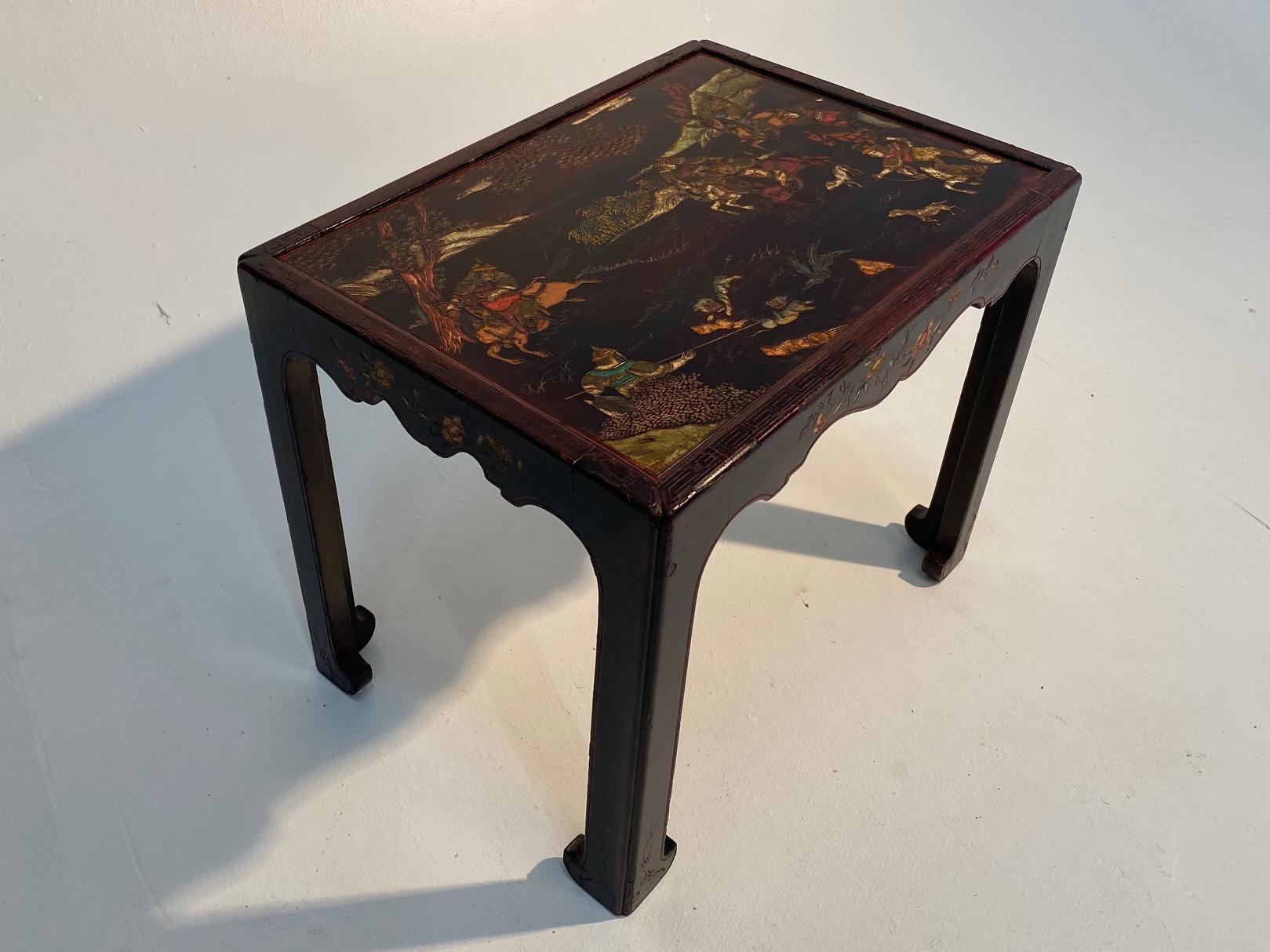 A beautifully shaped French black lacquer end table having gorgeous Chinoiserie decoration with scalloped apron and Classic Asian style legs.