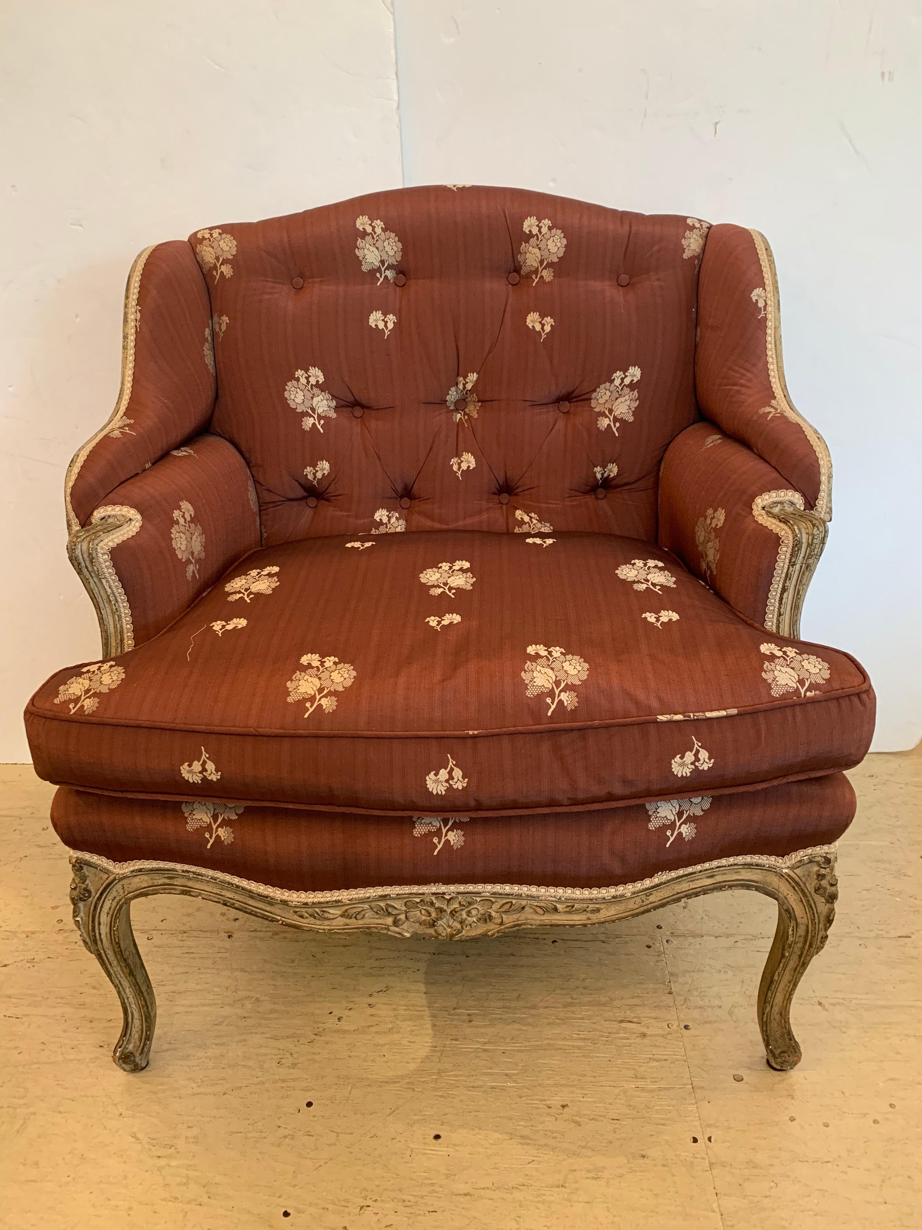 A romantic French Louis XV armchair, generous in width but still feminine in stature having a worn creamy painted finish upholstered in a Rose Tarlow silk with trim detail. Cabriole legs and open back are additional points of beauty. The chair is