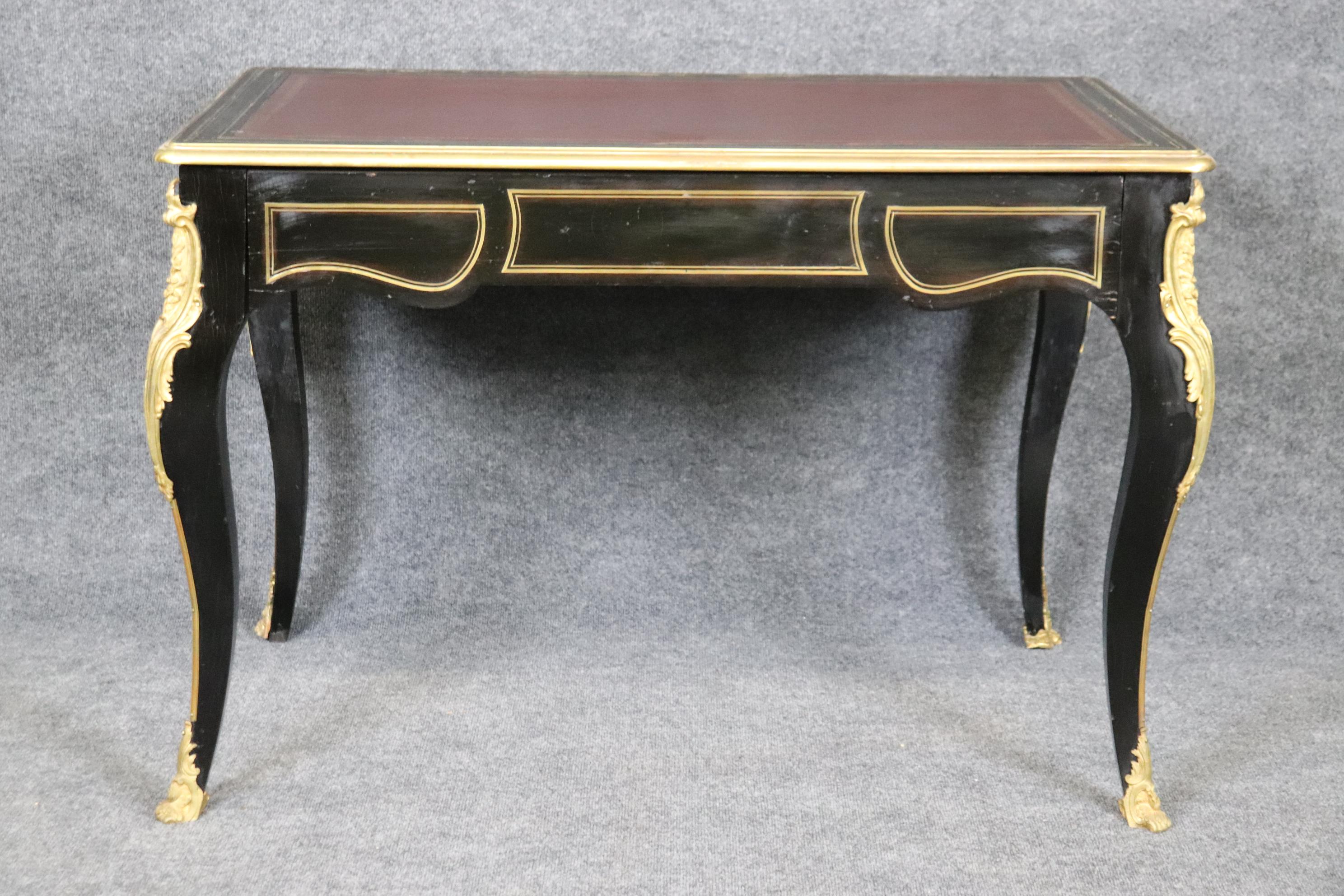 This is a gorgeous superb quality desk. The desk features incredible bronze ormolu and mounts and a rich leather top. The desk Measures 43.5 wide x 27 deep x 30 tall. Dates to the 1970s era. 