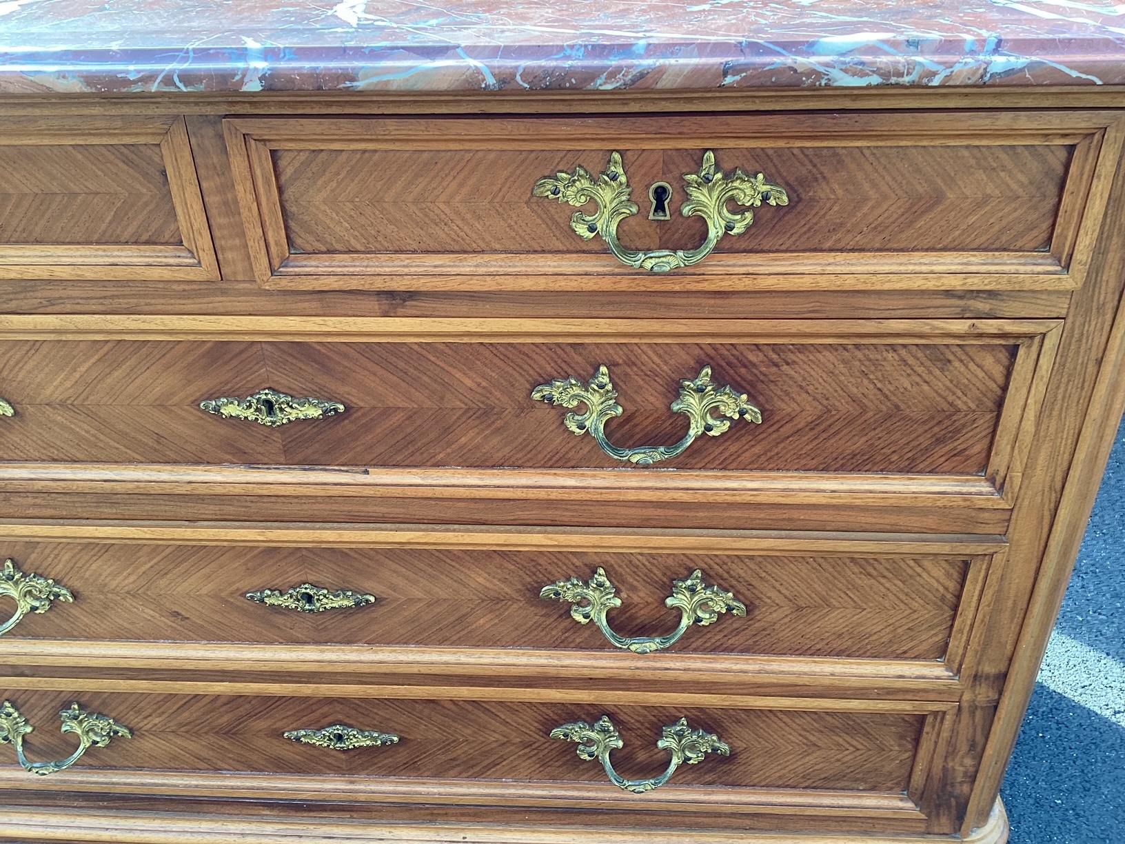 Lovely walnut commode dresser from Brittany having delicate carvings, generous drawer space, and a richly patterned marble top.  The back splash is a wonderful touch.  Would make an elegant toilette table for your makeup and perfumes. All original