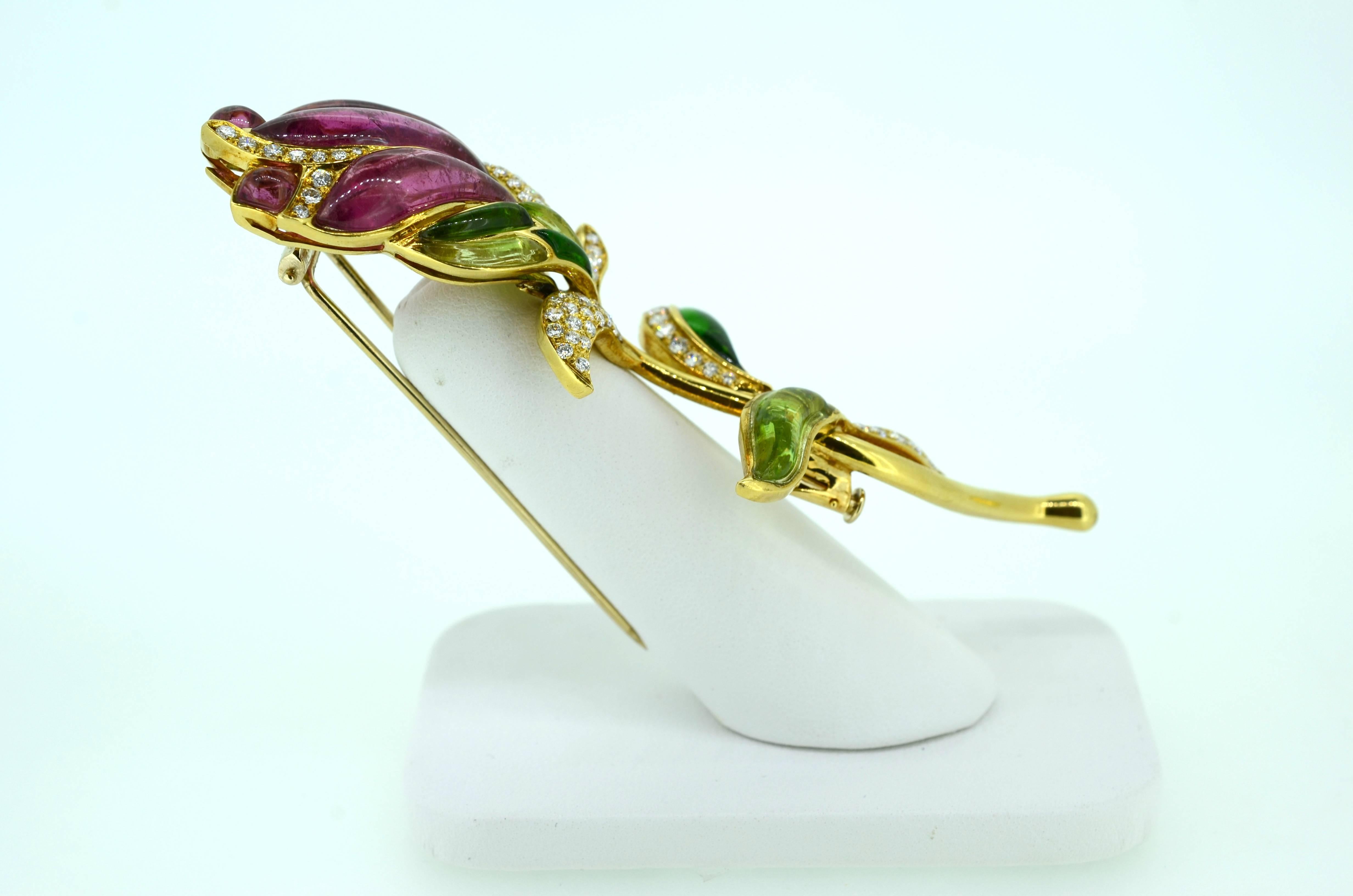 Gorgeous gemstone brooch: 18kt gold, one of a kind graceful floral design with stem and leaves; a statement piece. 3.75 inches long and at the widest point 1.5 inches. The brooch is made of carved and cabochon cut leaves and petals made of Pink and