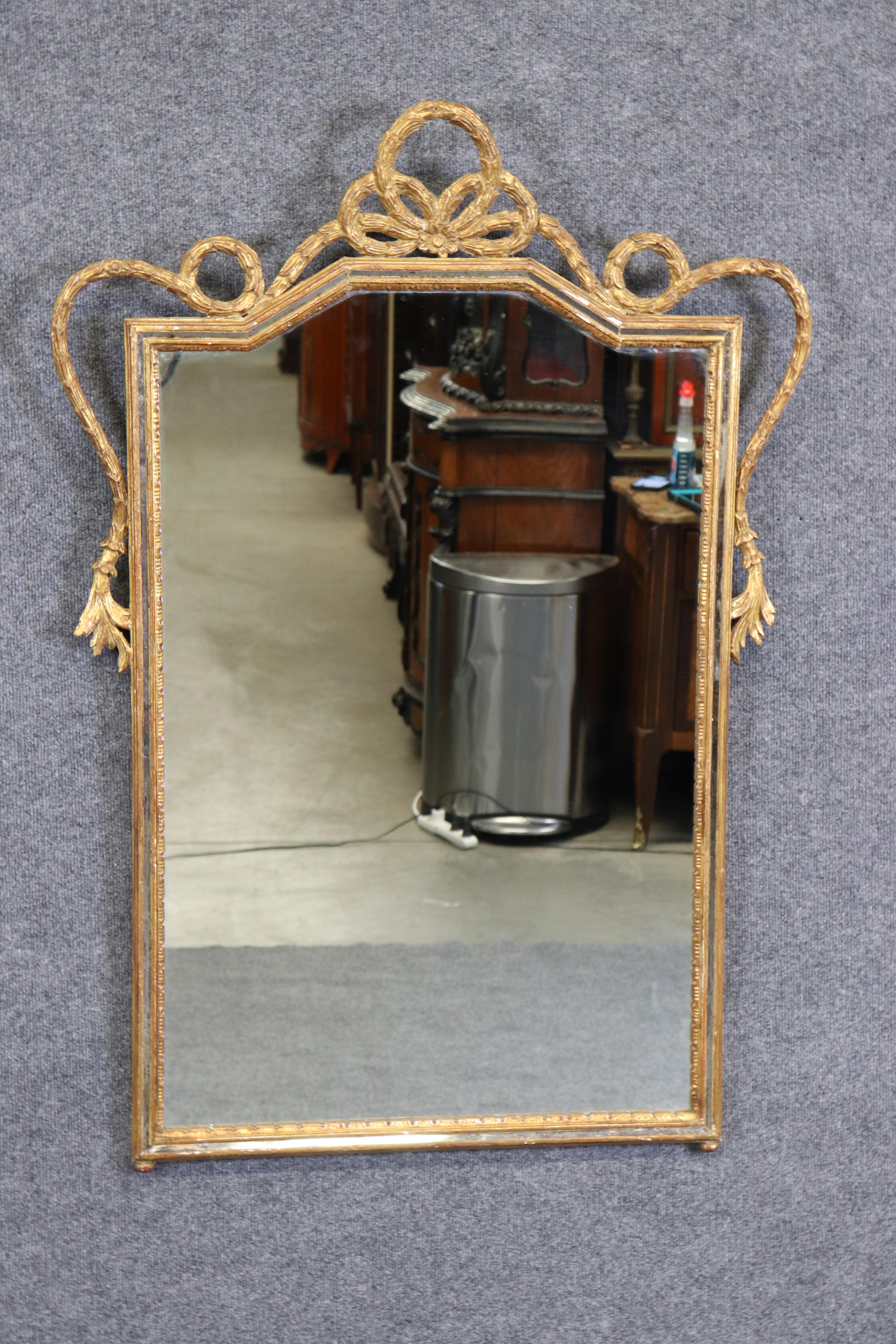 This is a gorgeous Italian mirror with all of the hallmarks of the Italian carvers. Look at the faux Bois and flower motif. Notice the gorgeous gold leaf details and patina. The mirror plate is clear and the mirror itself is in good condition. It