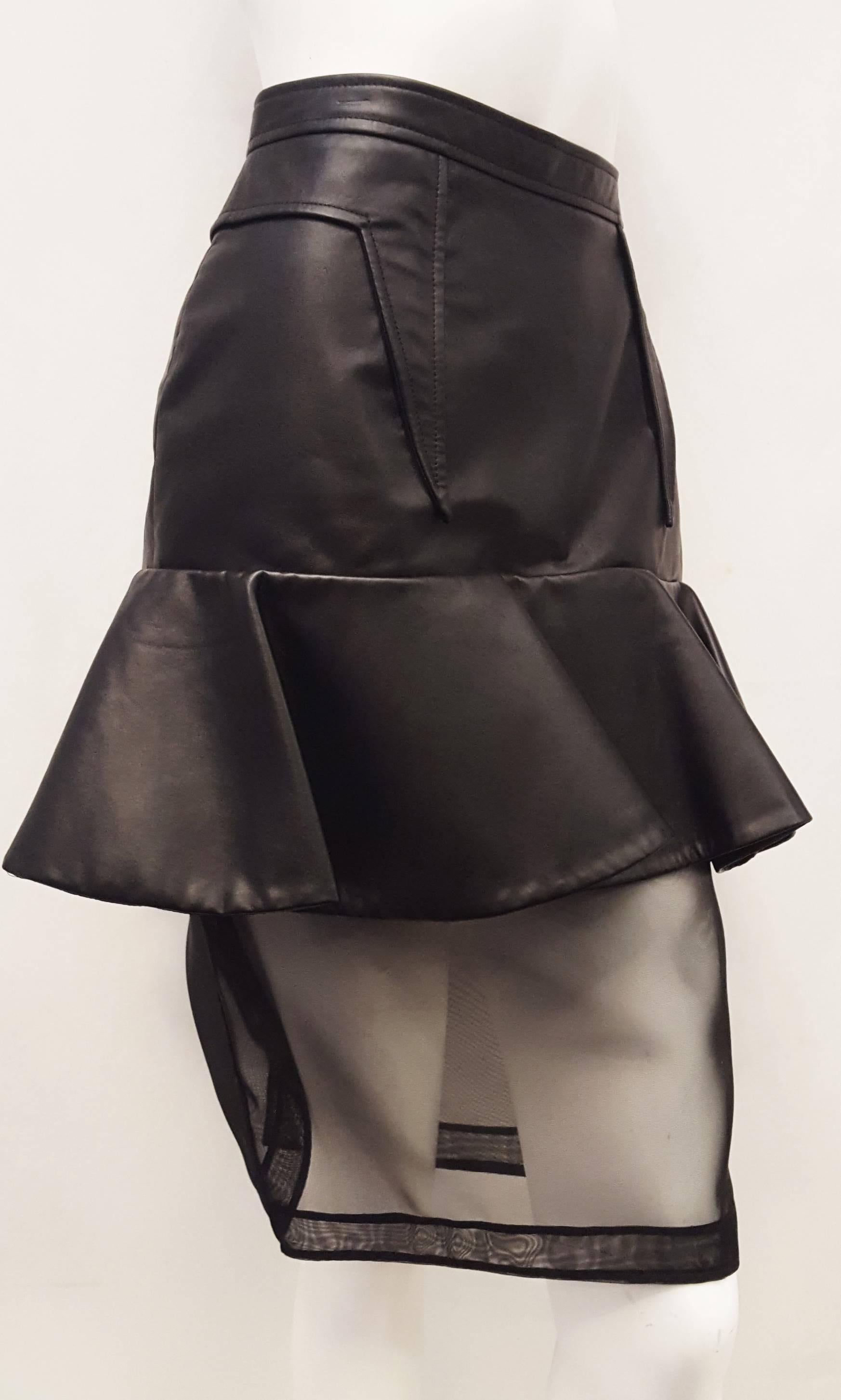 Givenchy features a unique black leather skirt tight to hip with one 7 inch ruffle all around for additional flare.  Below the ruffle is a pencil skirt with see-through mesh underskirt and a rear slit. The front and back contain darts that come down