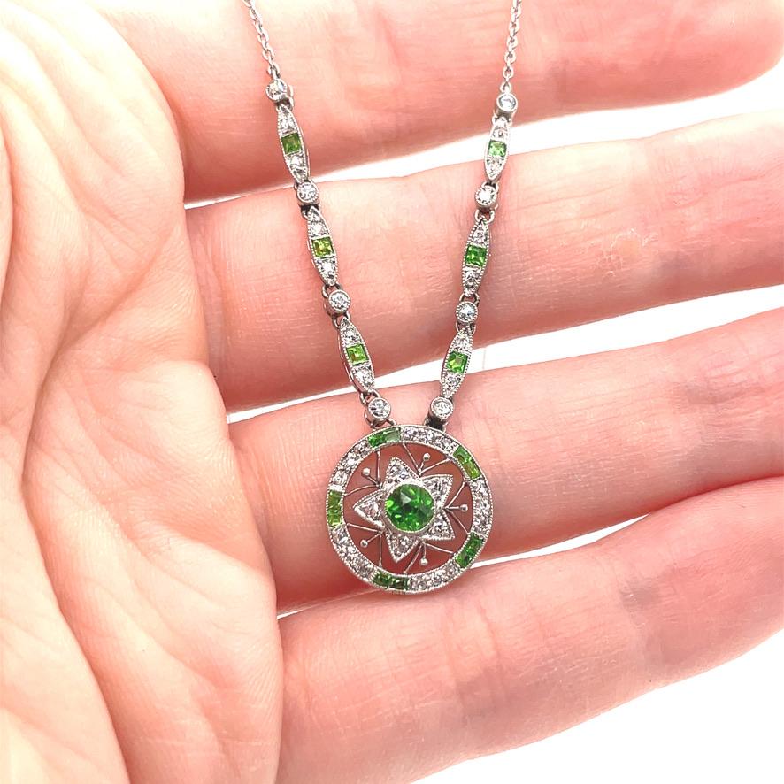 Exquisite Edwardian necklace.  A circular drop, with a star motif in the center.  Set with brilliant green demantoid garnets and very fine old European cut diamonds. Suspended from an 18