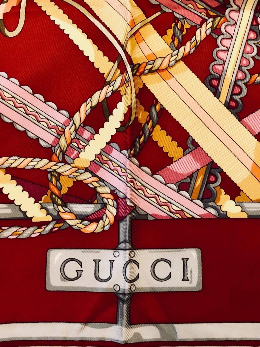 Gucci Garnet scarf celebrates the ornamental trim that takes minimal designs to maximum impact!  Features ultra-luxurious silk twill fabric printed with a multitude of ribbons, tassels, and ropes in a variety of colors allover.  Finished with hand