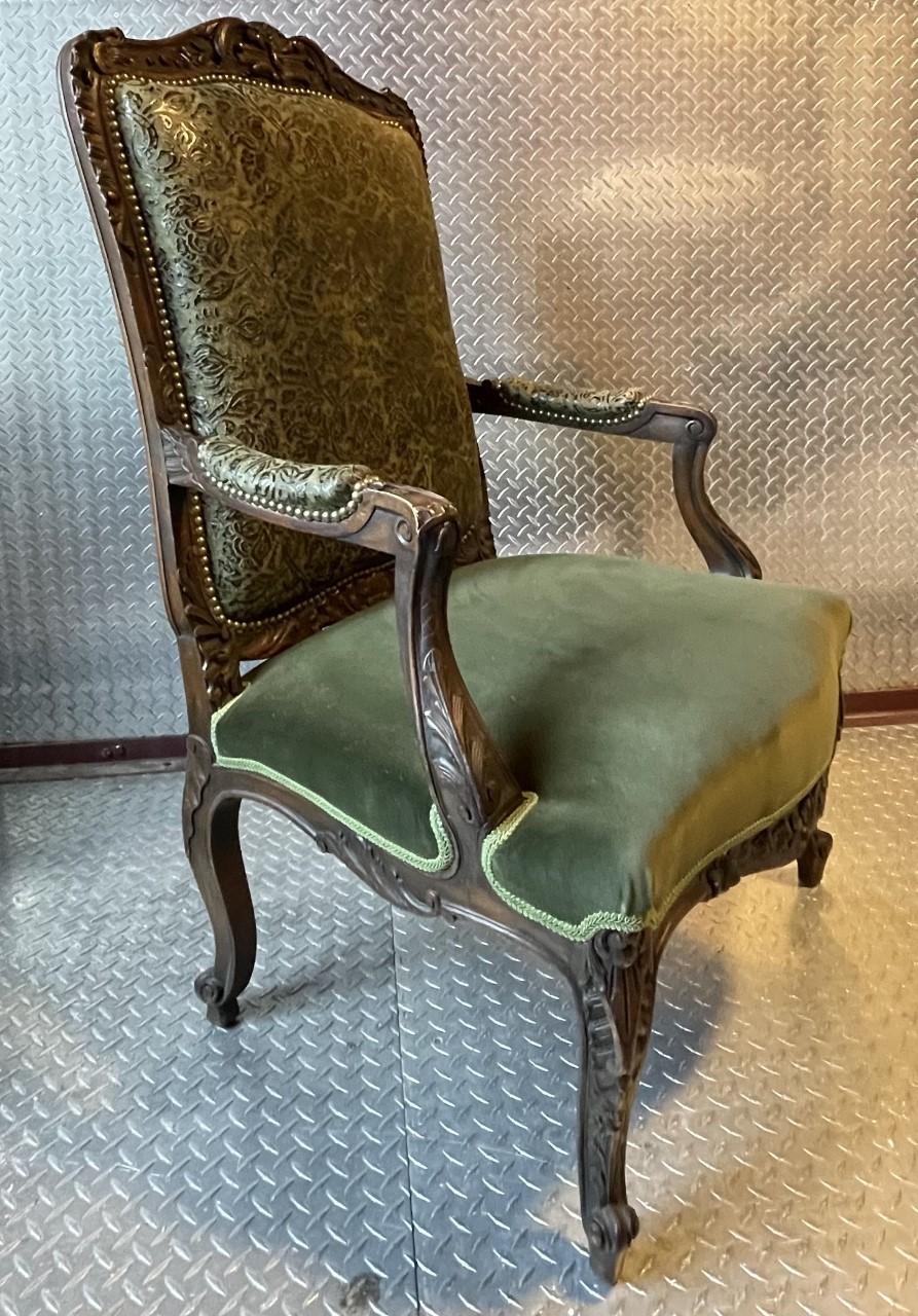 fully restored and refurbished beautifully detailed, carved arm chair with custom leather interior back panel and complimentary matching velvet seat, outside back and welt. A decorative nail-head border has been added to enhance its signiificance. . 