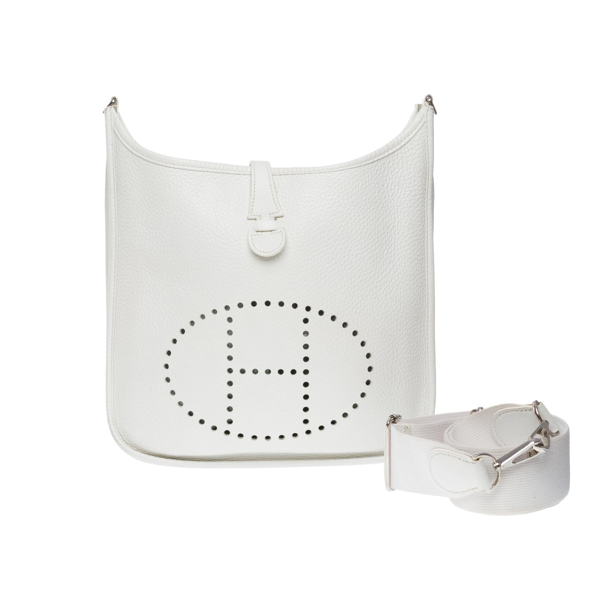 The Iconic Hermes Evelyne 29 shoulder bag in White Taurillon Clémence leather, silver metal hardware, a removable shoulder strap in white canvas for a shoulder or crossbody carry

Snap closure on flap
Back patch pocket
White suede