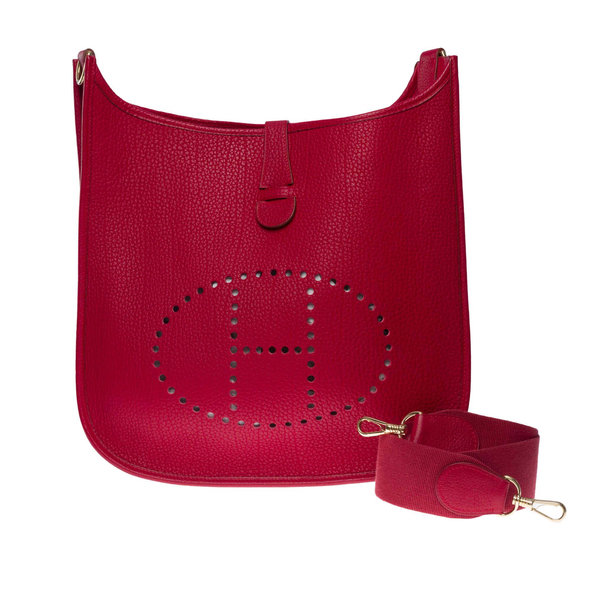 The Iconic Hermes Evelyne 33 (Grand Modèle) shoulder bag in Red Casaque Togo leather, gold metal hardware, a removable shoulder strap in red canvas for a shoulder or crossbody carry

Snap closure on flap
Red suede interior
Signature: 