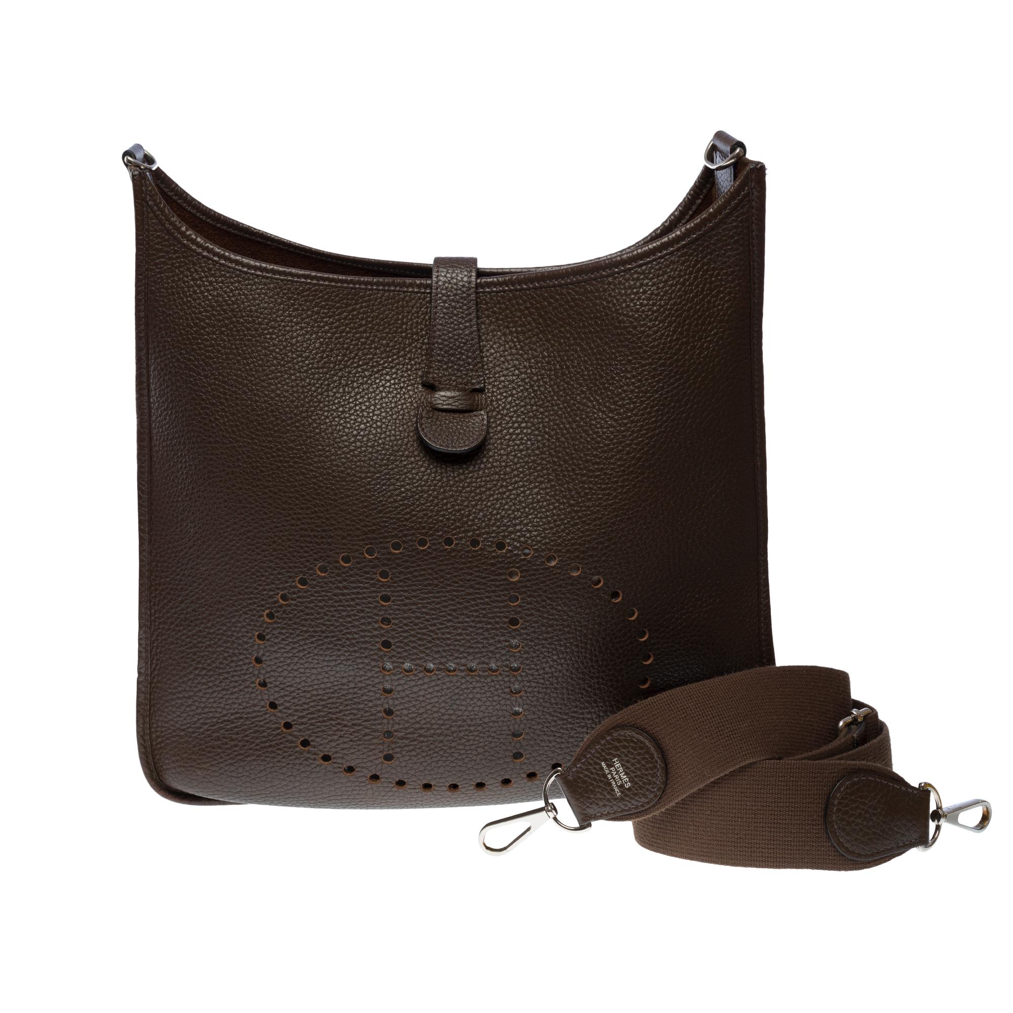 The Iconic Hermes Evelyne 33 shoulder bag in Brown Taurillon Clemence leather, silver metal hardware, a removable shoulder strap adjustable in brown canvas allowing a shoulder or crossbody carry

Closure by snap button on flap
Brown suede