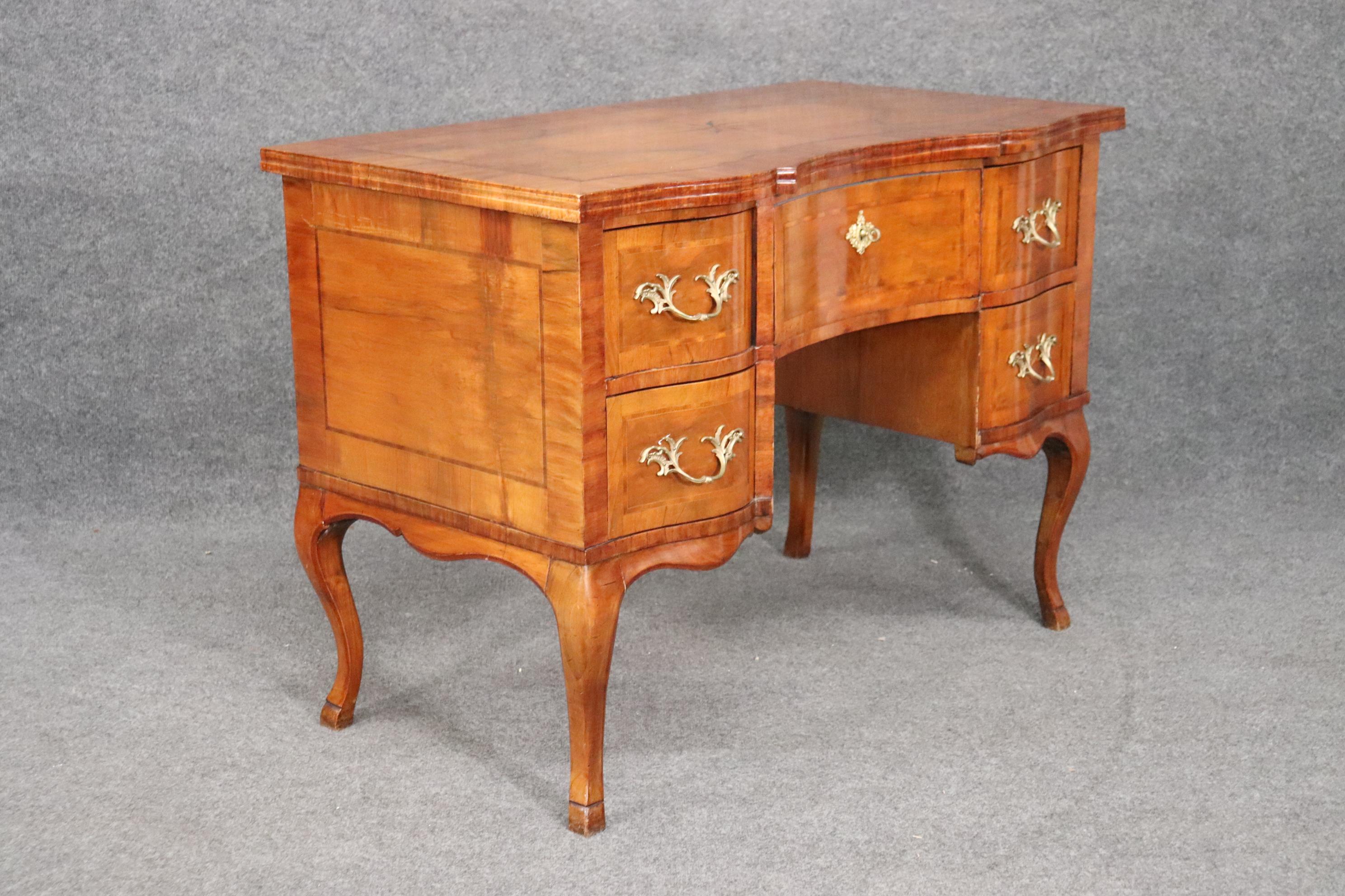 This is a beautiful desk that features the design of a Louis XV desk and has the traits of an Italian desk as well. The desk has beautiful inlay and even bronze hardware. The desk measures 45 wide x 25 deep x 32 tall. Dates to the 1920s.
