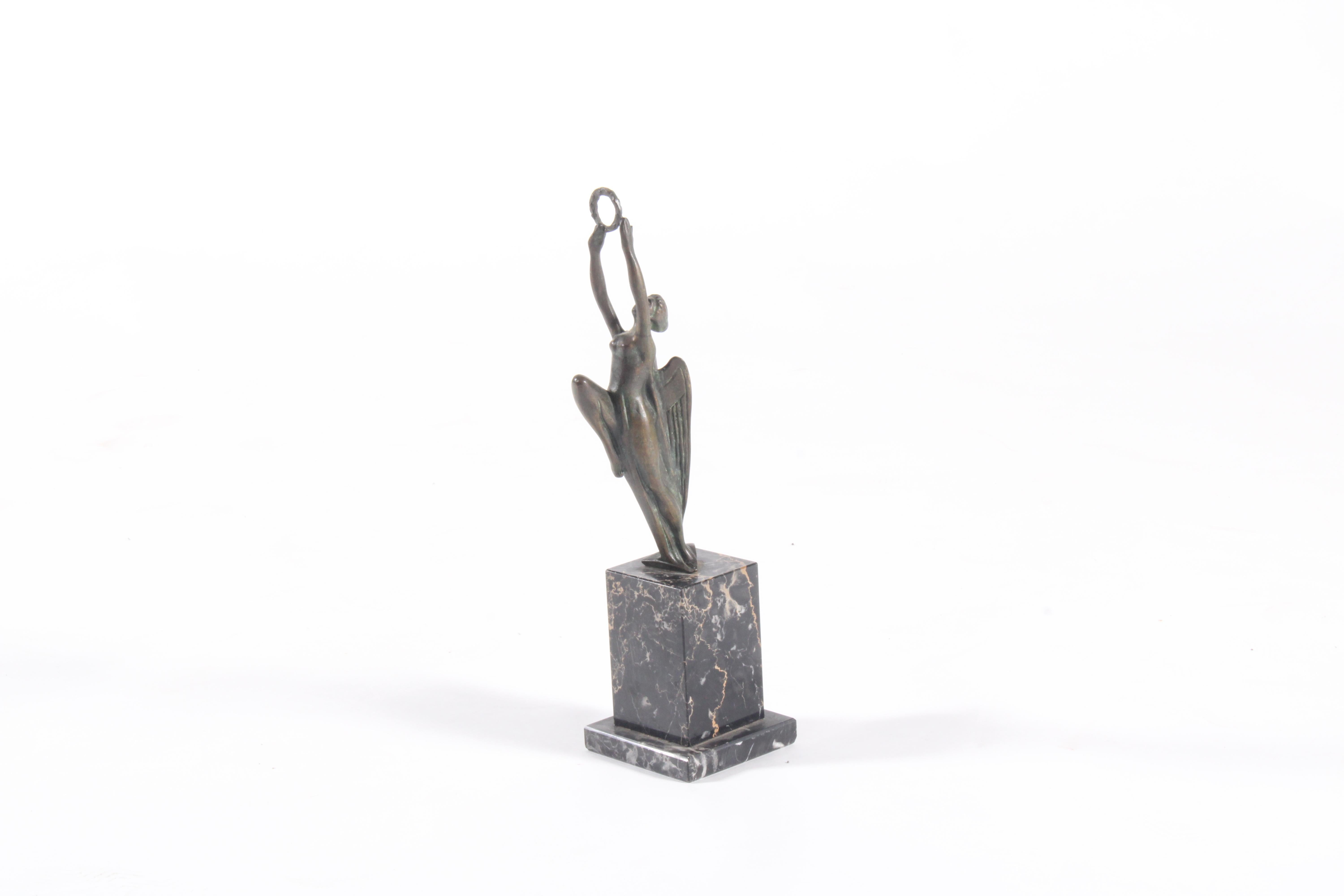 Rehaussez votre collection avec cette étonnante sculpture en bronze de style Art déco, d'une hauteur d'environ 42 centimètres. Elegamment posée sur un socle en marbre noir poli, la pièce capture un moment dramatique de mouvement ascendant, lorsqu'un