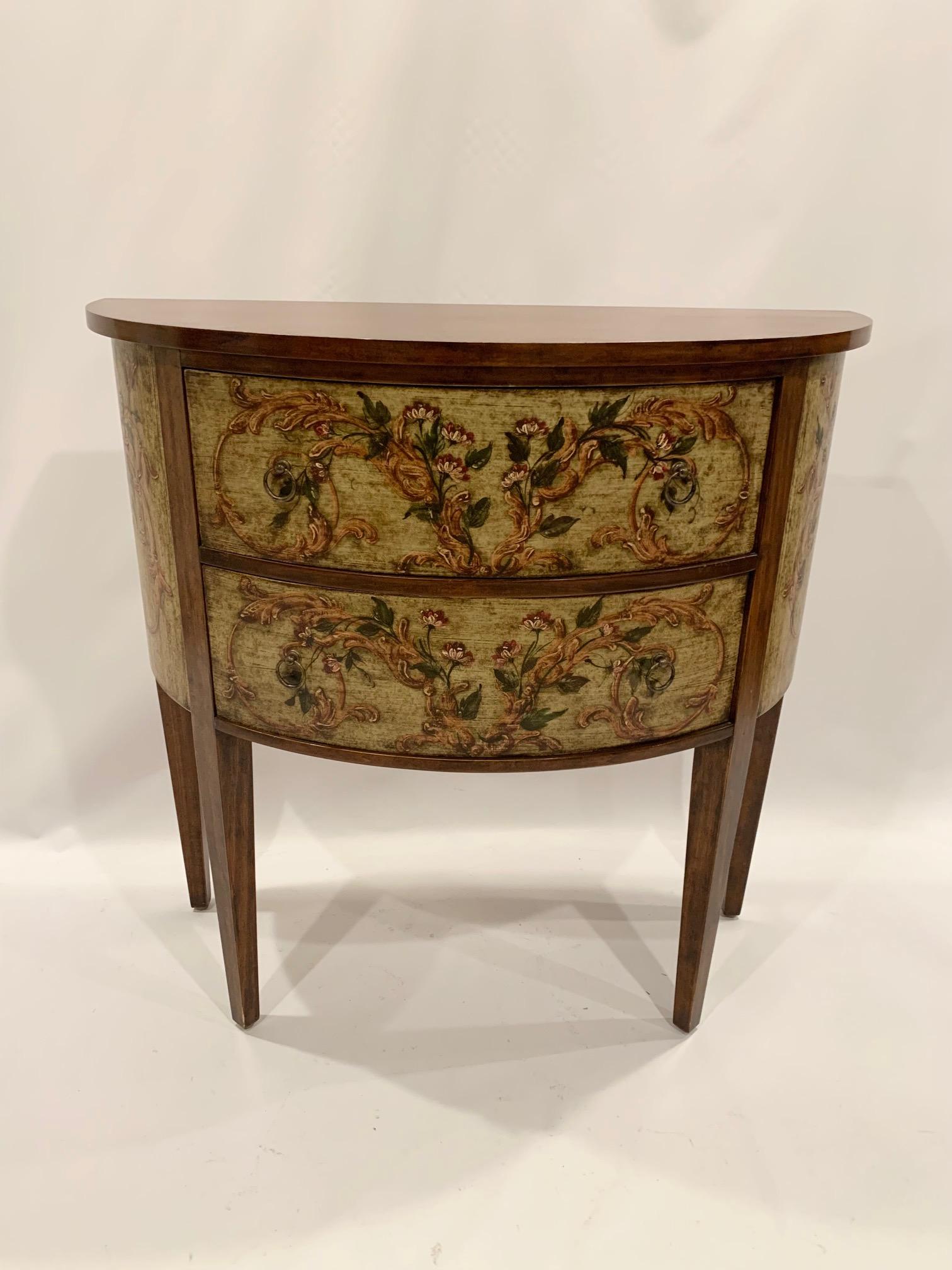 Very pretty Italian demilune table having rich fruitwood top and painted body with 2 drawers. The decorative painting has an antiqued cream finish with earth colored floral motif. Some of the natural brown fruitwood is carried through in the
