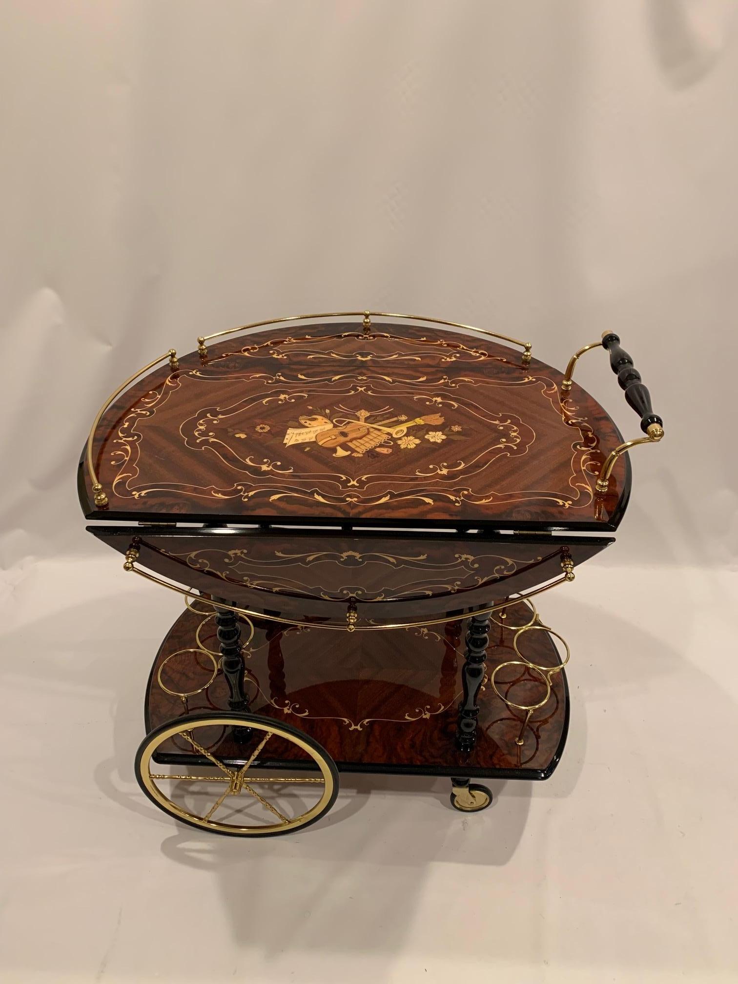 Richly elegant Italian drop leaf bar cart having meticulous inlay and mixed woods as well as lovely brass accents. When the two leaves are extended the cart is 30