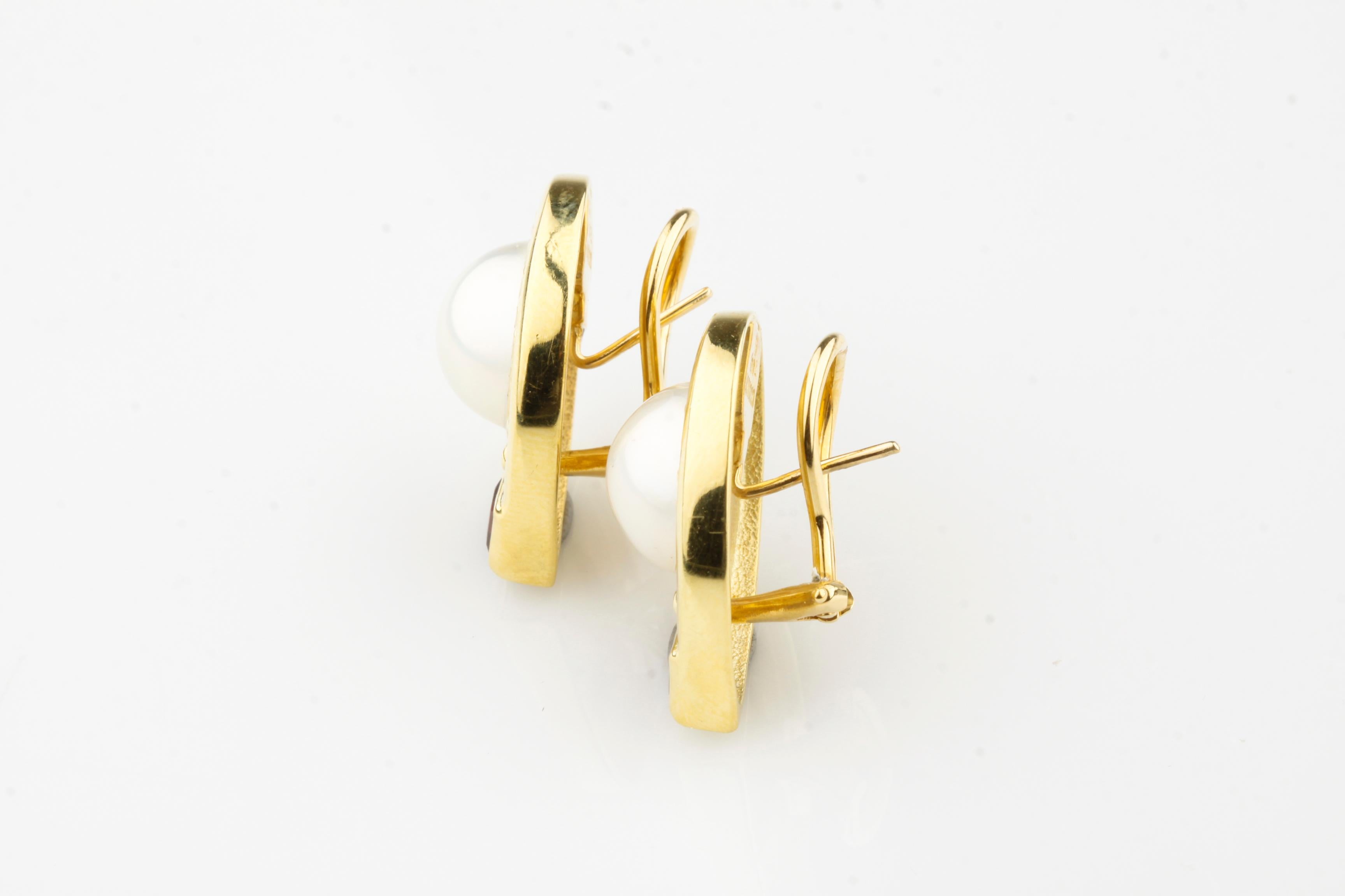 Gorgeous Pearl Earrings by JJ Marco
Part of Etruscan Series (Released in Early 90s)
Feature 12.5 mm Bezel-Set Pearls in 18k Yellow Gold Settings
Include 2 Princess Cut Pink Sapphire Accents (Appx TCW = 1 carat)
Length of Earrings = 24 mm
Width of