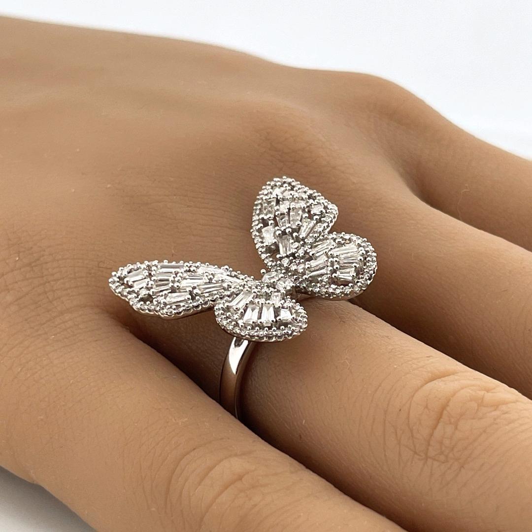 Entrez dans le monde de l'élégance intemporelle avec notre bague 'Graceful Cluster Diamond Butterfly', une fusion envoûtante de beauté délicate et de sophistication. Réalisée en or blanc étincelant 14K, cette bague enchanteresse présente un papillon