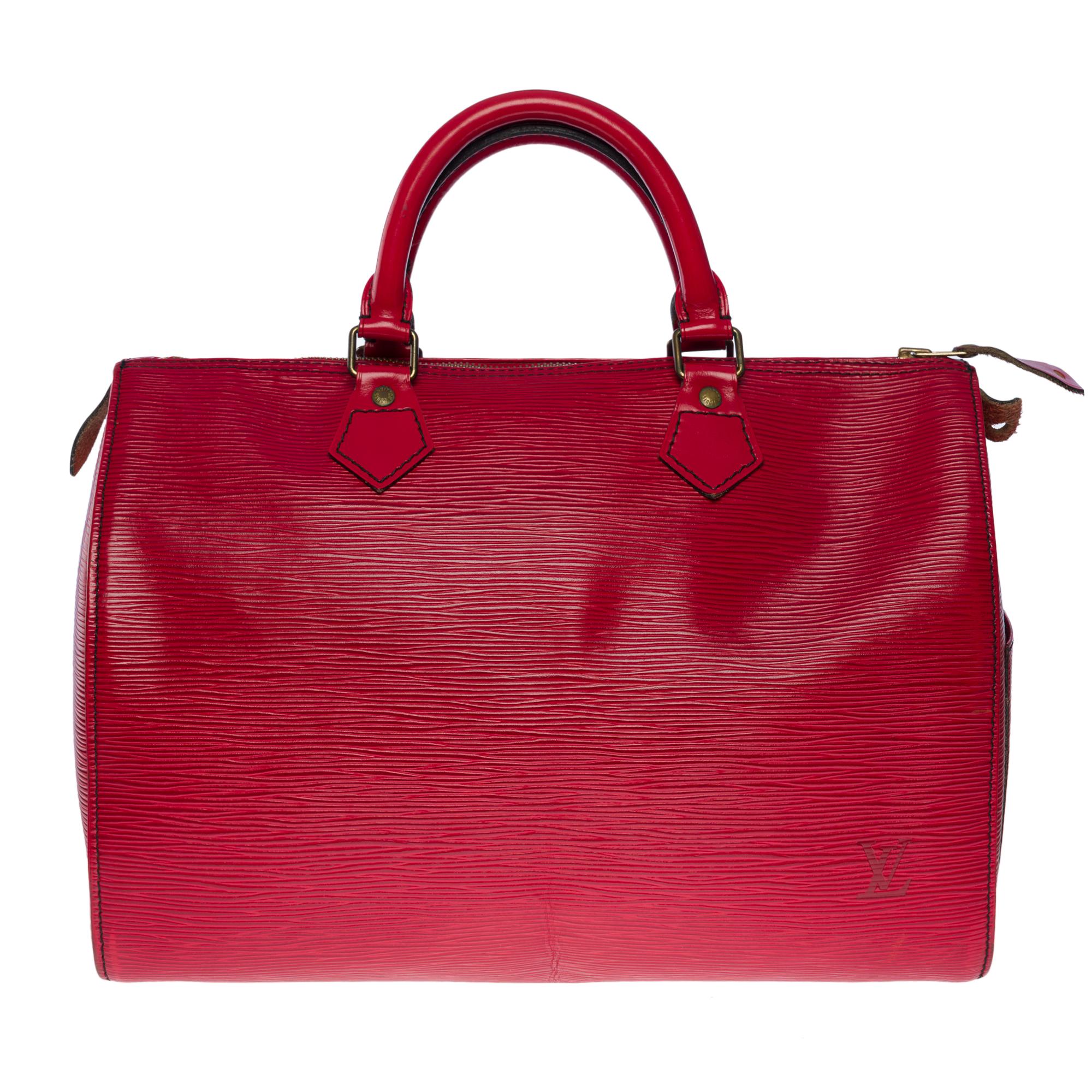 Die unentbehrliche Louis Vuitton Speedy 30 Handtasche aus rotem kastilischem Epi-Leder, mit vergoldeten Metallbeschlägen und doppeltem rotem Ledergriff, der ein Tragen in der Hand ermöglicht

Reißverschluss
Rotes Wildleder innen eine aufgesetzte