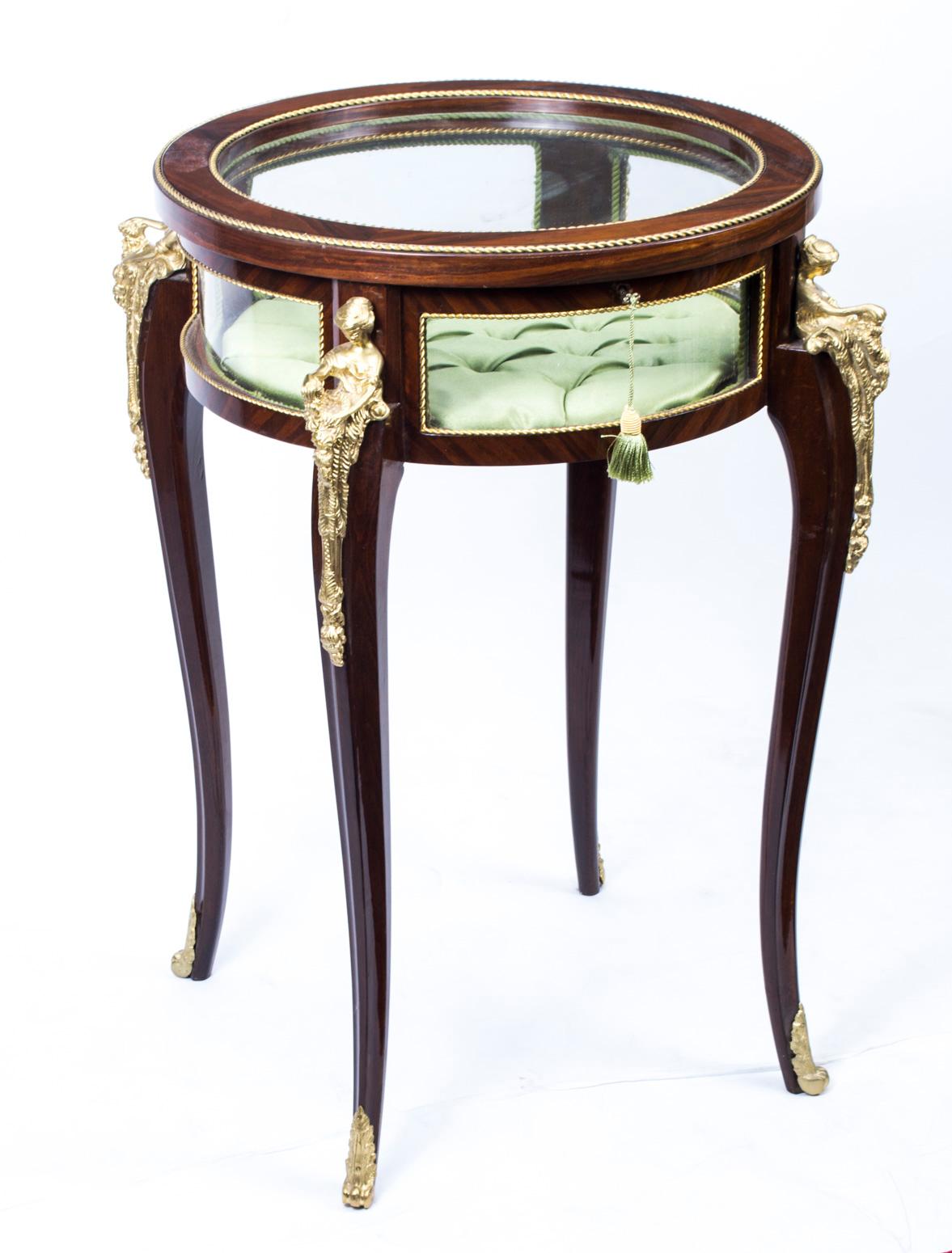 This elegant little display table is in the style of the Louis XVI period, and dates from the last quarter of the 20th century.

It is carefully crafted in rich rosewood with exquisite ormolu mounts, and it has a plush satin interior. 

It
