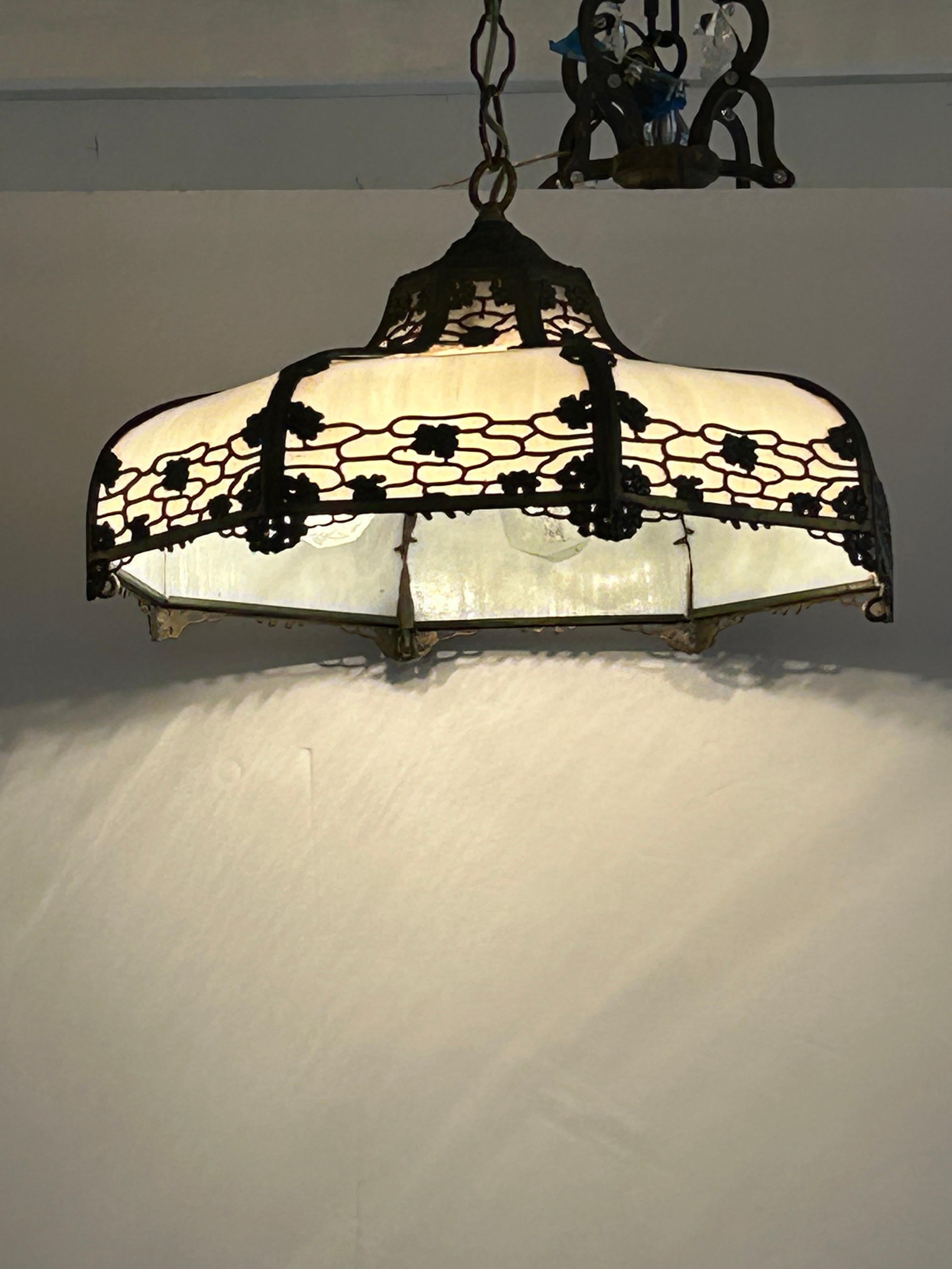 Beautiful Victorian Tiffany style chandelier having white milk glass adorned with bronzed metal overlay.   4 bulb sockets and 3 ft of chain.