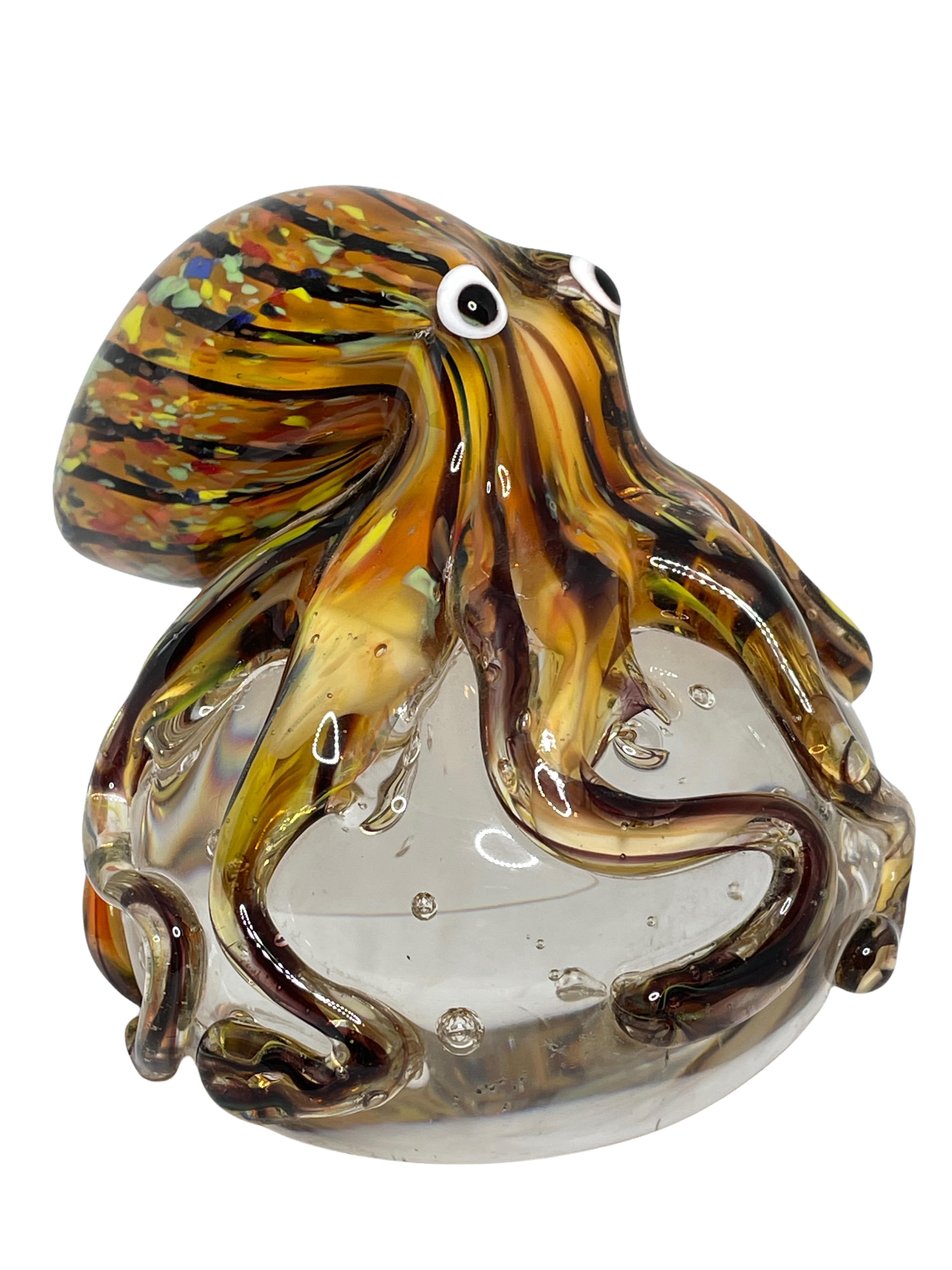 Beautiful Murano hand blown aquarium Italian art glass paper weight. Showing a giant octopuses, on a glass bubble floating on controlled bubbles. Colors are a blue, yellow, orange and clear. A beautiful nice addition to your desktop or as a