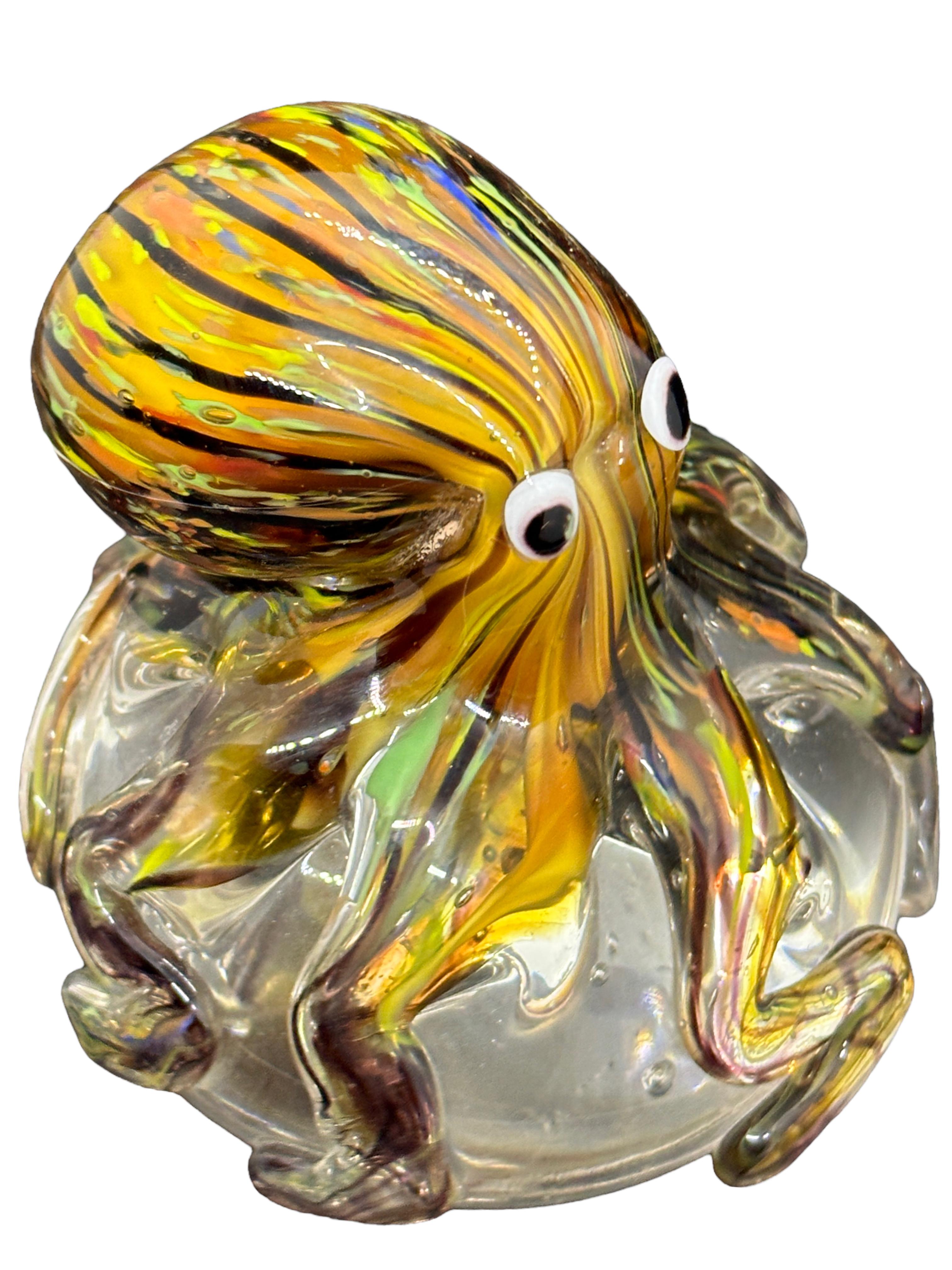 Beautiful Murano hand blown aquarium Italian art glass paper weight. Showing a giant octopuses, on a glass bubble floating on controlled bubbles. Colors are a blue, yellow, orange and clear. A beautiful nice addition to your desktop or as a