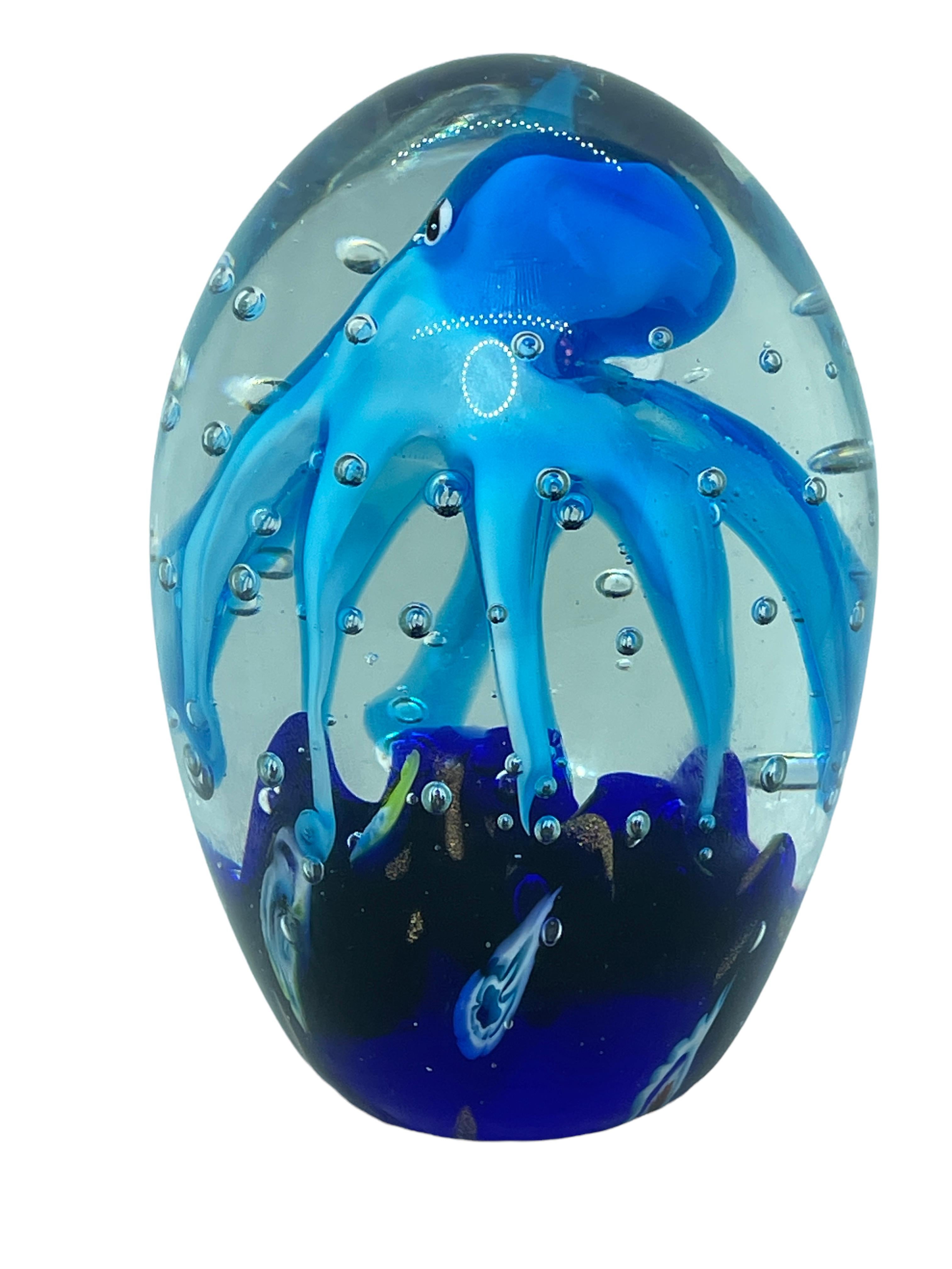 Beautiful Murano hand blown aquarium Italian art glass paper weight. Showing a giant octopuses, in a glass bubble floating on controlled bubbles. Colors are a blue, yellow, red and clear. A beautiful nice addition to your desktop or as a decorative