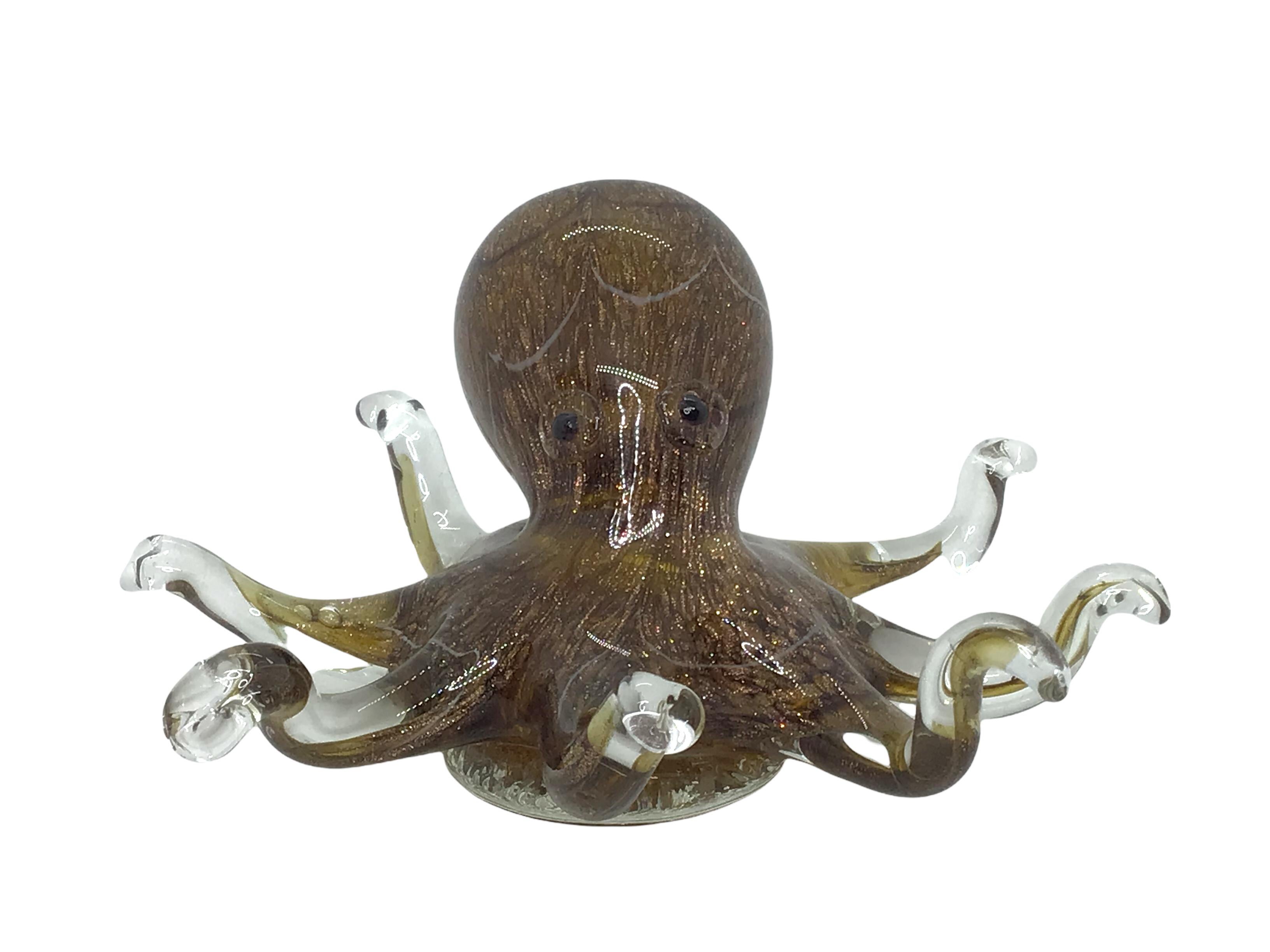 Beautiful Murano hand blown Italian art glass paper weight or sculpture. Showing a giant octopus. Colors are a brown, grey, white, black and clear, with golden glitter. A beautiful nice addition to your desktop or as a decorative piece in every room.