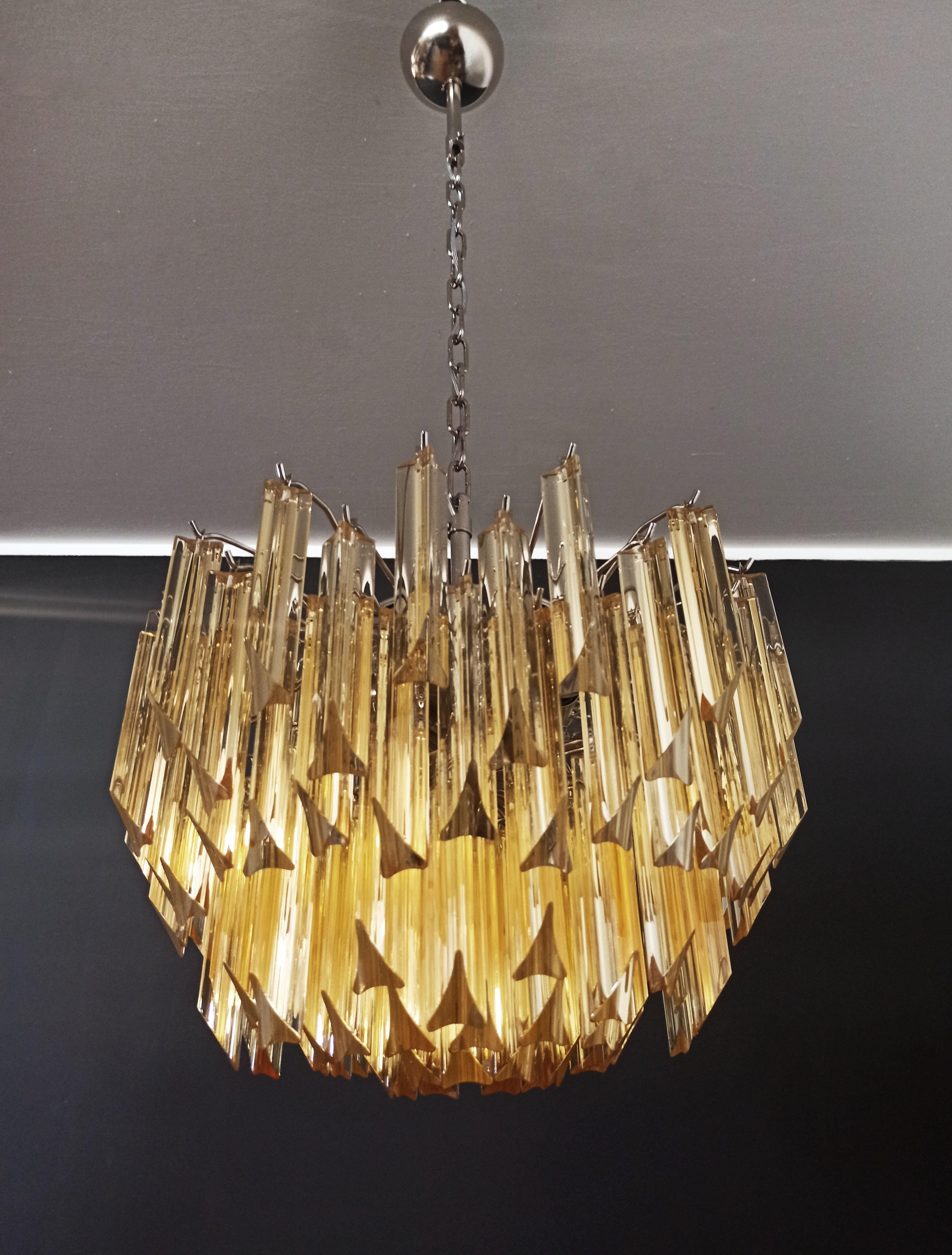 Fantastique lustre vintage Murano fait par 107 Murano cristal clair ambre prism triedri dans un cadre en métal nickel.
Période : 1980'S
Dimensions : 41.90 pouces de hauteur (108 cm) avec chaîne, 17.70 pouces de hauteur (45 cm) sans chaîne, 17.70