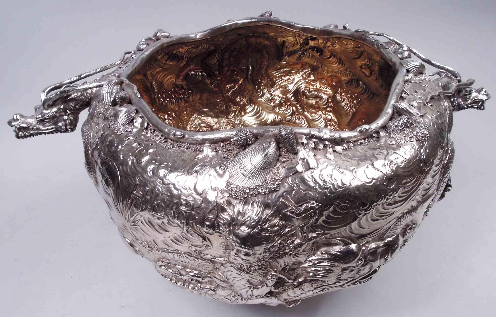 Gorgeous museum-quality Japonesque sterling silver trophy bowl. Made by Gorham in Providence in 1884. Large and round with allover ornament in relief. Horned serpents swim slack-jawed through the water. Talons and heads 