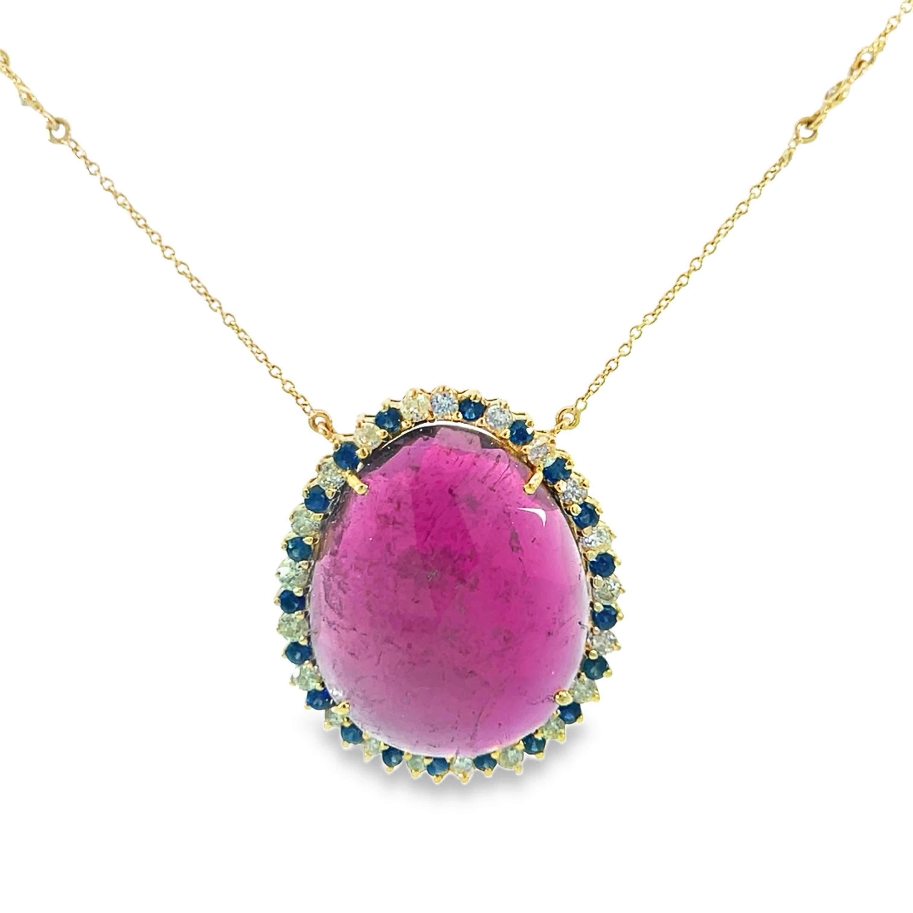 Un magnifique or 14 carats forme une énorme tourmaline de 23,33 carats dans ce superbe pendentif. Des saphirs bleus étincelants de 0,65 carat et des diamants de 0,84 carat mettent en valeur le design sophistiqué, ce qui en fait la pièce d'apparat