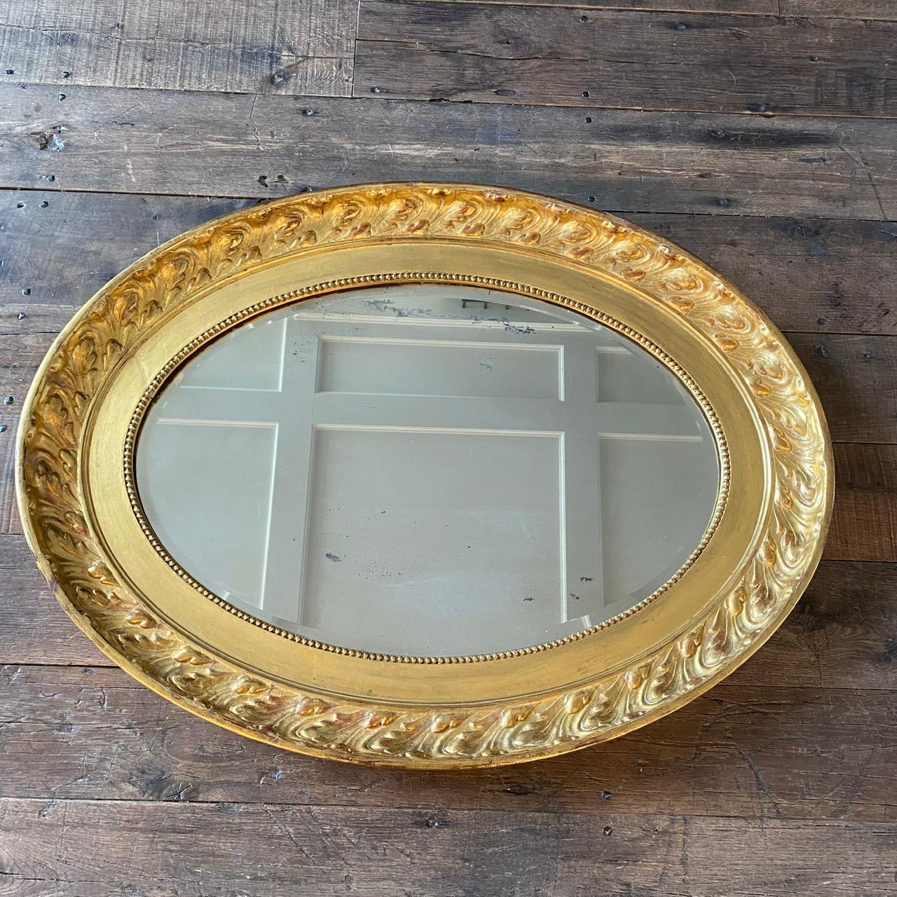 Il s'agit d'un magnifique miroir avec une finition à la feuille d'or authentique et brillante, avec des touches d'argile rouge italienne broyée derrière la feuille d'or. La plaque miroir est propre et claire. Peut être accroché verticalement et