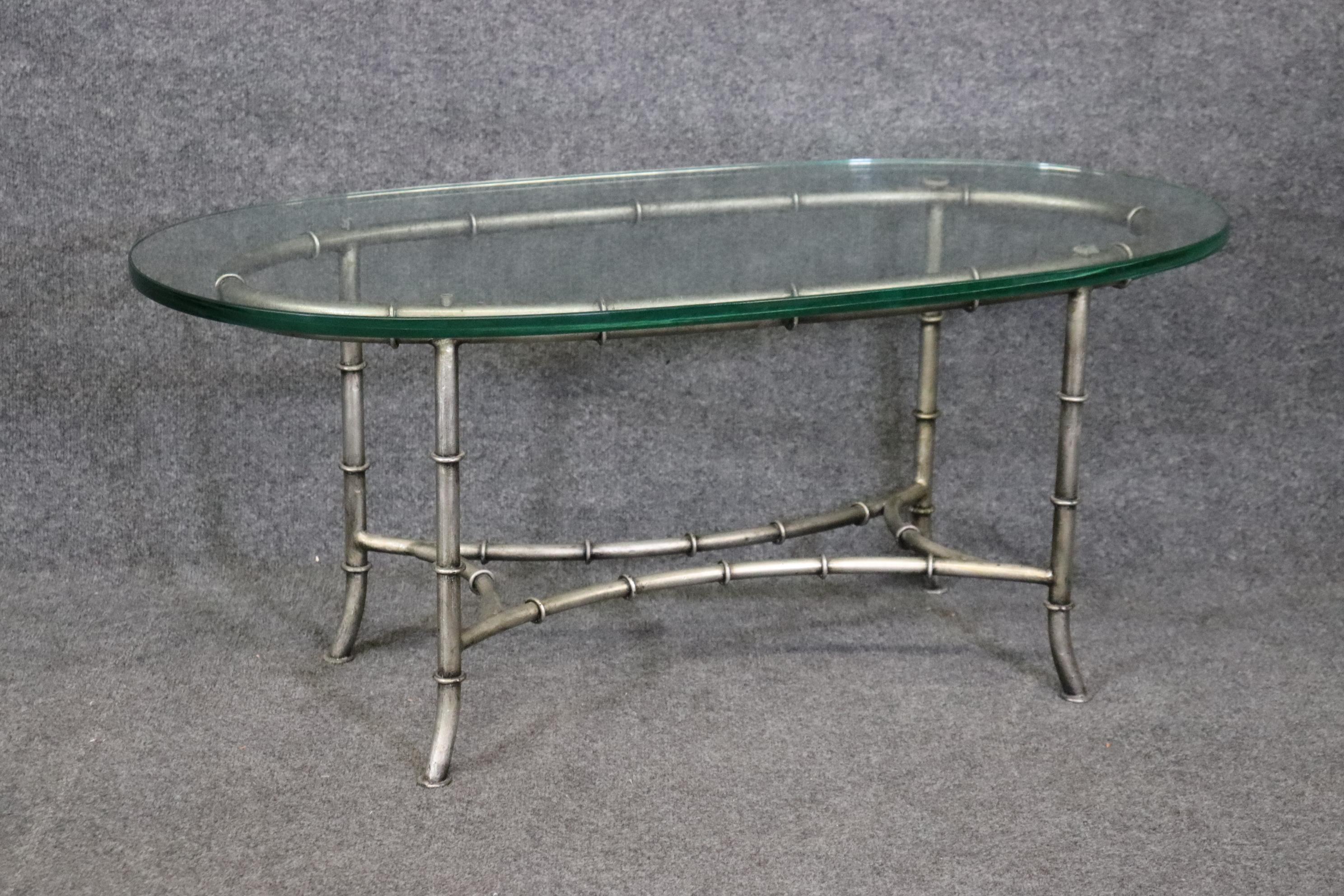 This is a gorgeous coffee table in the style of the French company Maison Bagues who made some beautiful faux bamboo coffee tables just like this one. The finish appears to be silver plated although I am not sure. The table is in good condition and