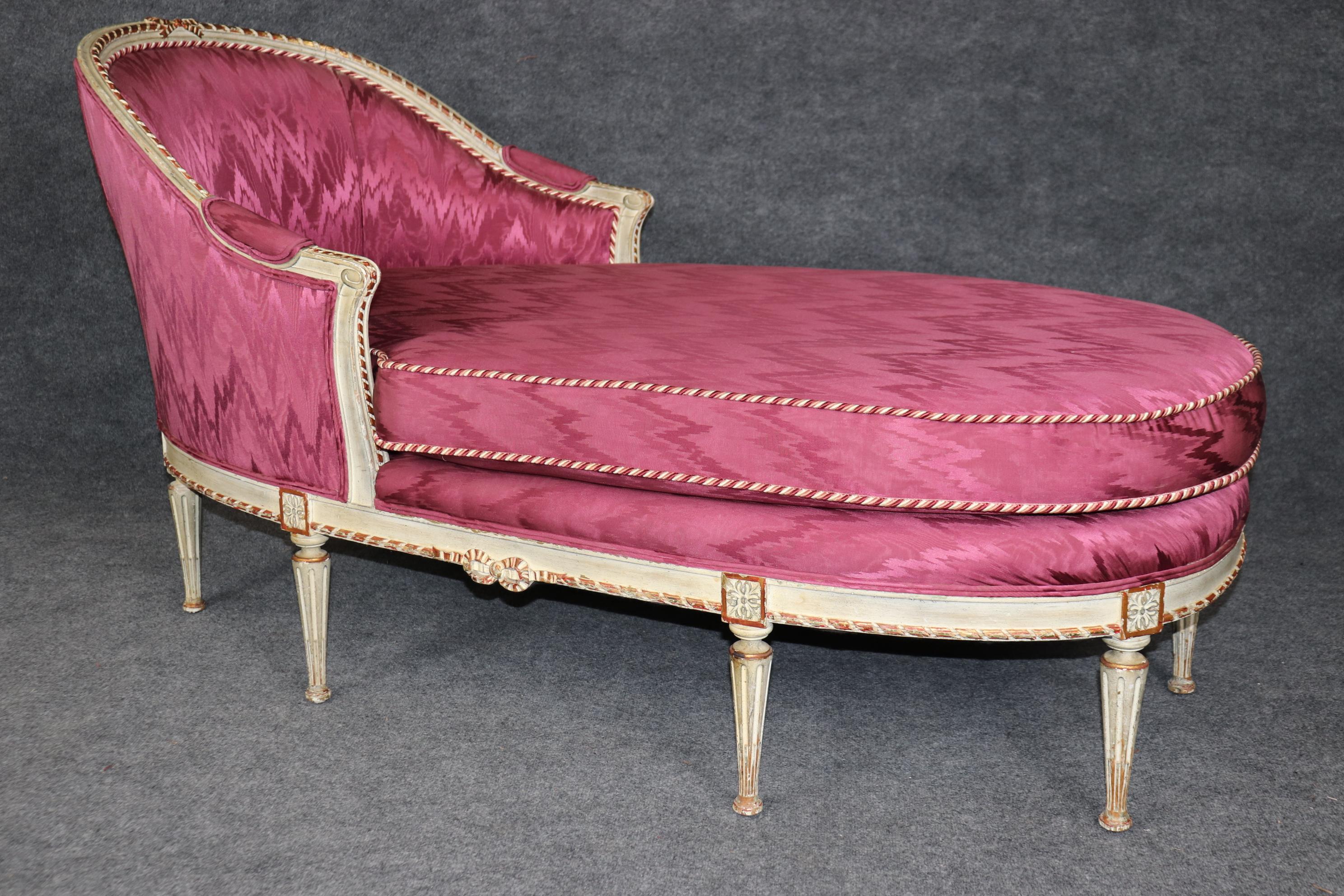 This is a gorgeous fuchsia upholstered creme painted French daybed. The daybed is in a vivid pinkish hue and in good condition with minimal signs of age and wear to teh upholstery but will show minor distressing to the frame. The daybed or chaise is