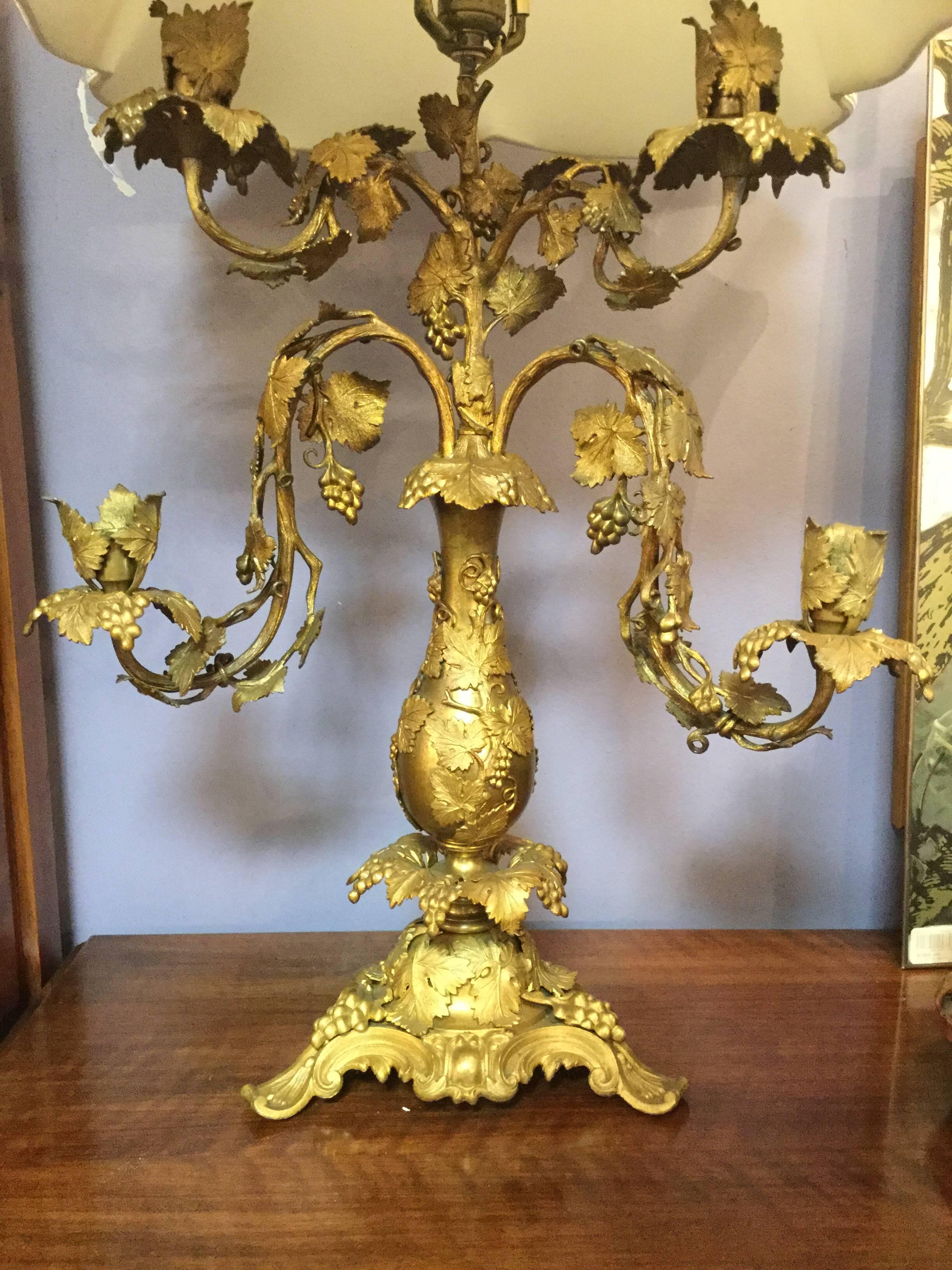 Gorgeous pair of French bronze doré lamps. circa 1900-1920, these lamps
feature gilt bronze grape clusters and leaves over richly wrought candelabra
arms. There are 4 arms on each lamp with bobeches that can hold candelabra
electric bulbs of 25