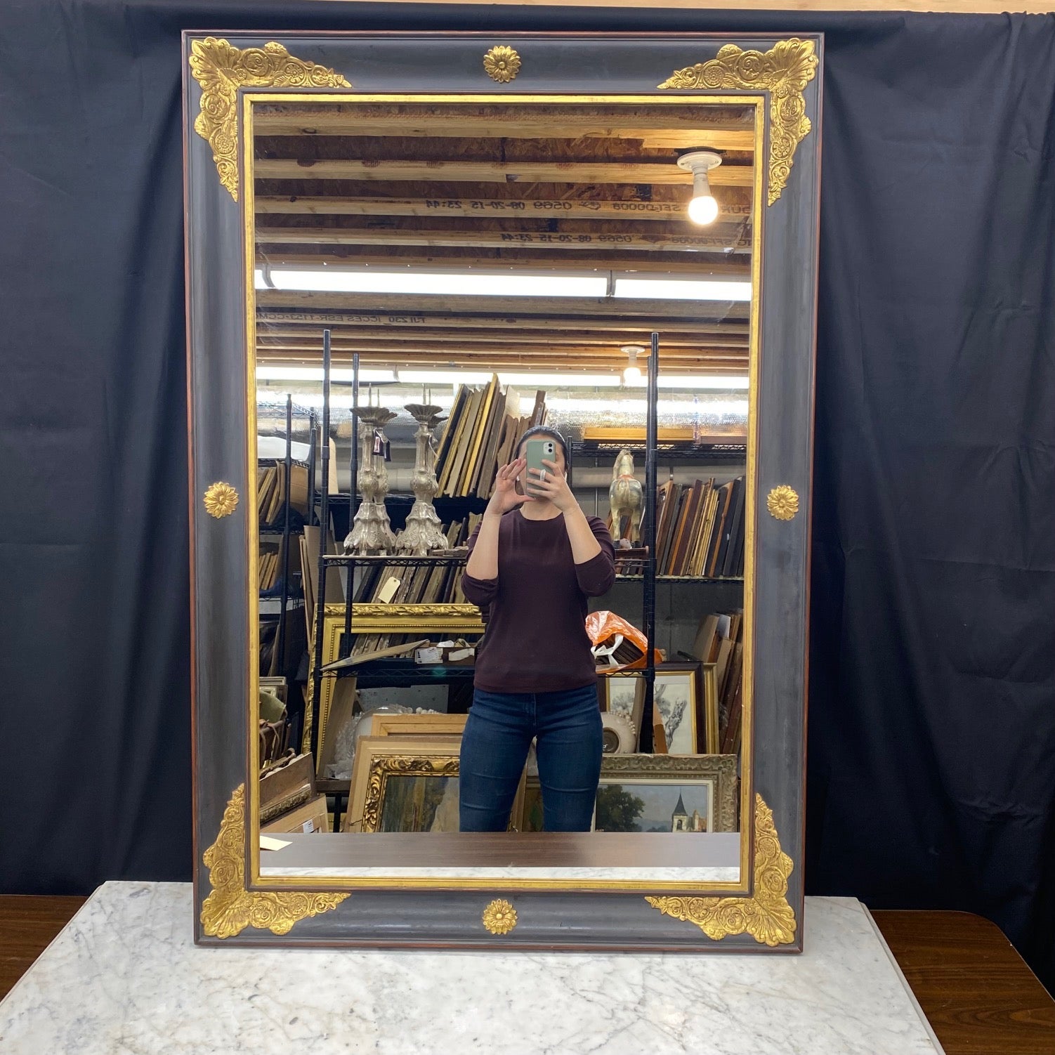 Bellissima coppia di specchi Eleg in oro dorato e nero ebano, che costituiscono un elegante pezzo forte. La finitura in legno dorato è completata da una bella patina di gesso lavato nero ebano,  e il motivo neoclassico in rilievo è un classico