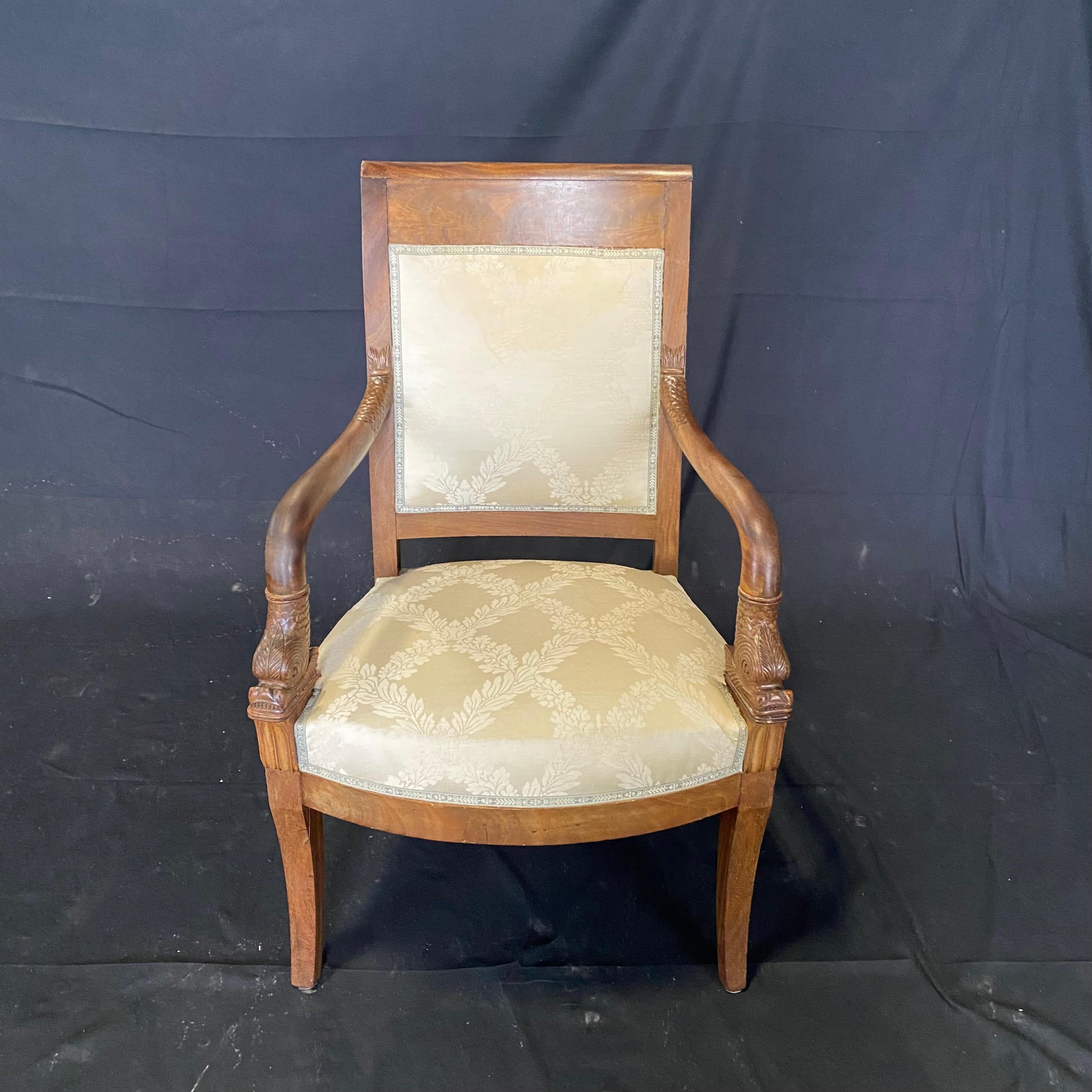 Handsome pair of classic French Empire walnut square back carved armchairs with stunning dolphin armrests. 
Measures: Seat height 17.5
Arm height 25.5
#6005.