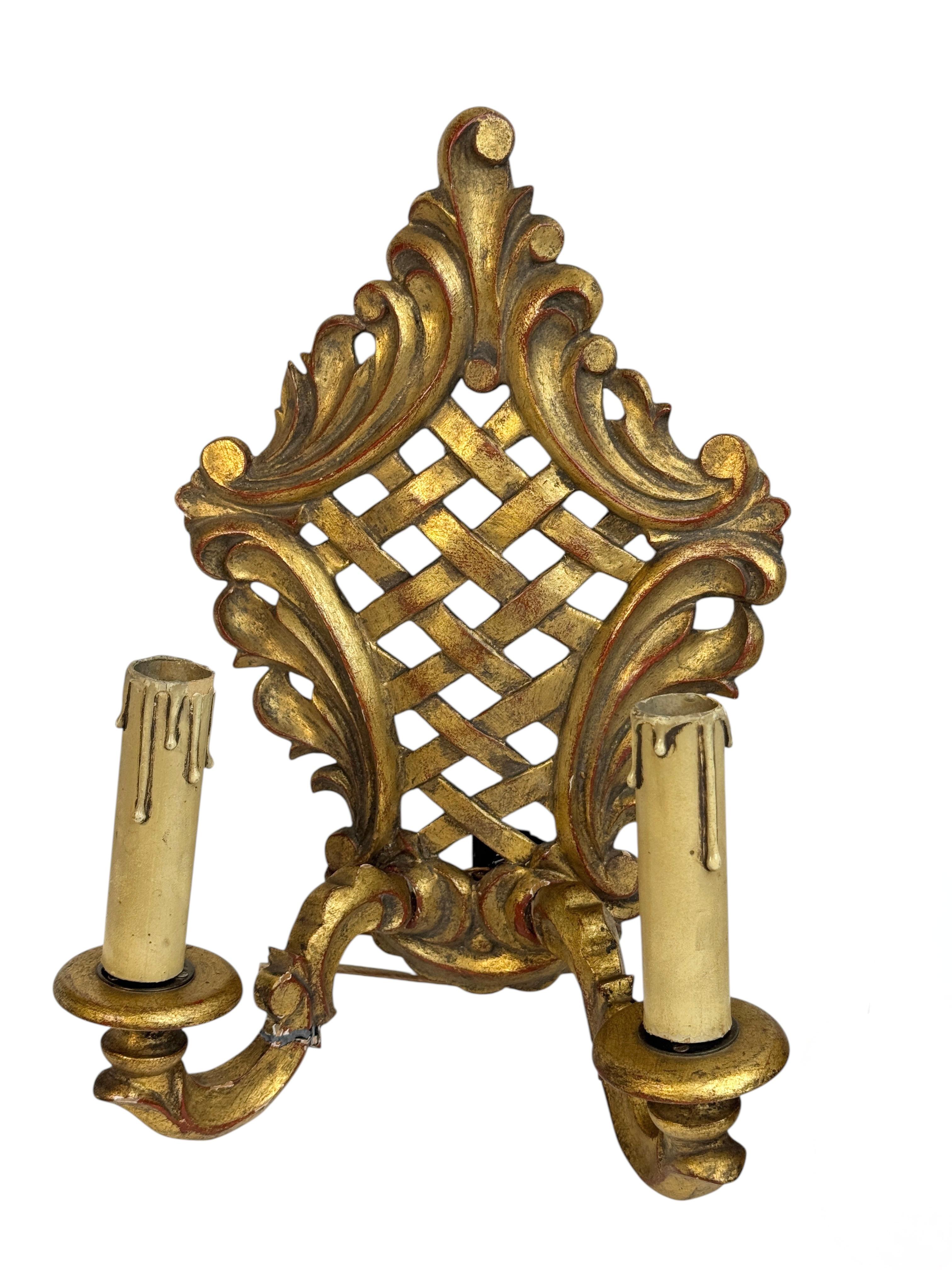 Add a touch of opulence to your home with this charming pair of sconces. Perfect gilded wood and metal to enhance any chic or eclectic home. We would like to see it hanging in an entryway as a charming welcome home. Constructed in the 1910s or