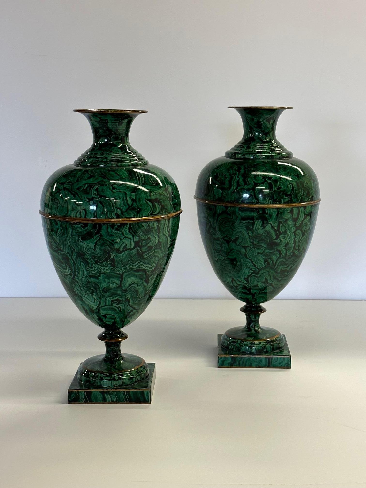 Gorgeous pair of emerald green enamel faux malachite urns having contrasting gilded details. Bases are 5.5 square.
RR.