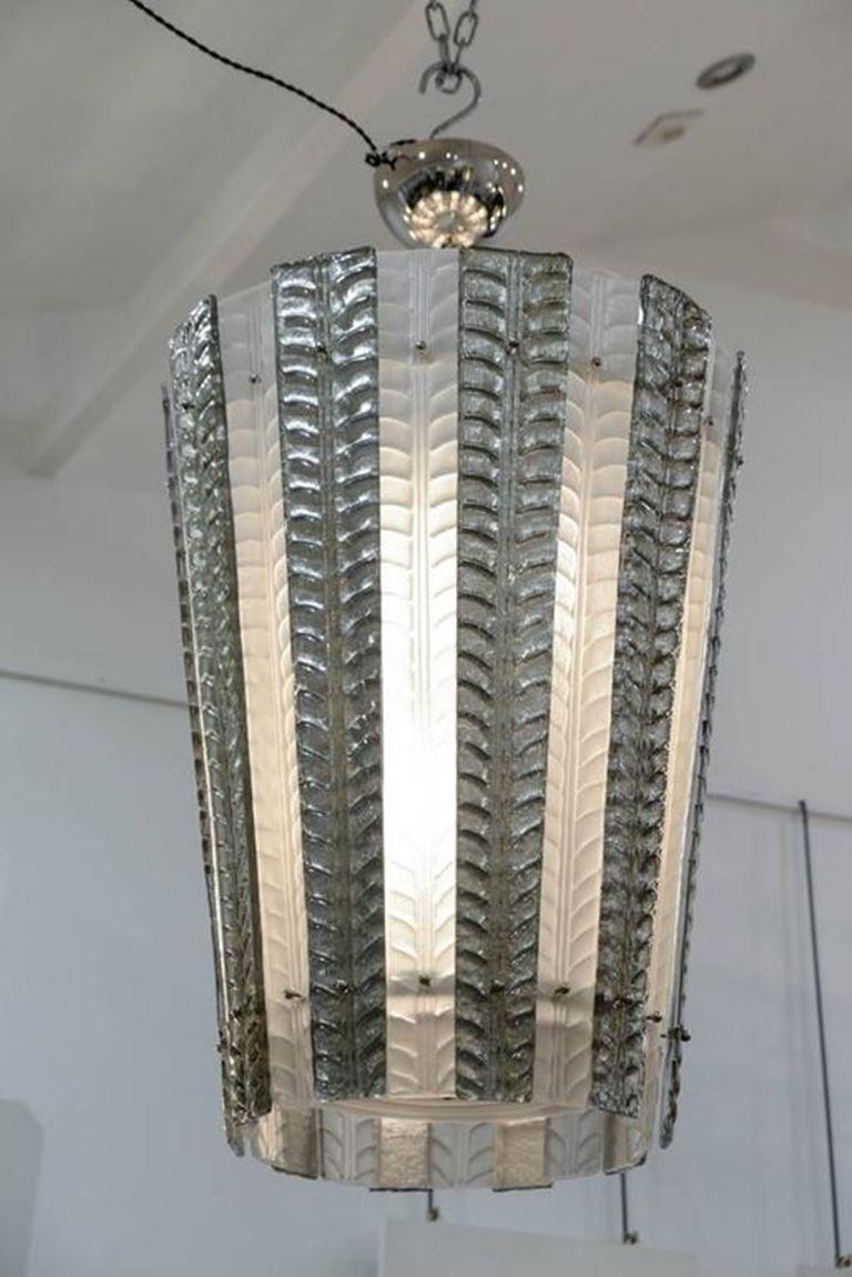 Coppia di lanterne in vetro di Murano in vetro pressato, patina argento.

Sei lampadine per ogni lanterna.