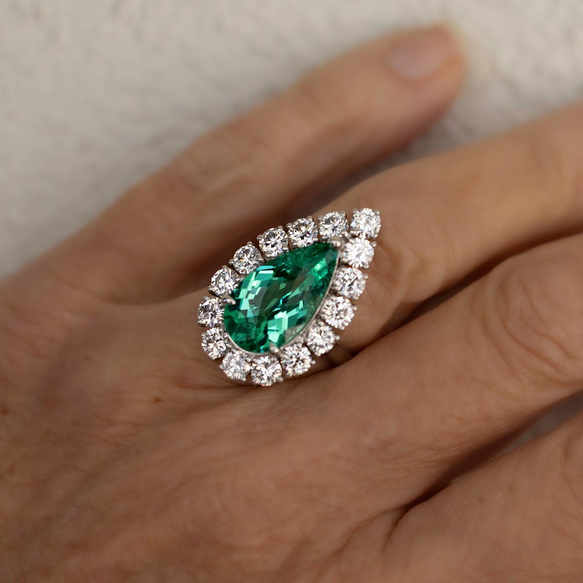 Platinum ring with a GRS certified 5.58 carat pear shape Paraiba Tourmaline and 15 round brilliant diamonds weighing 2.41 carats.