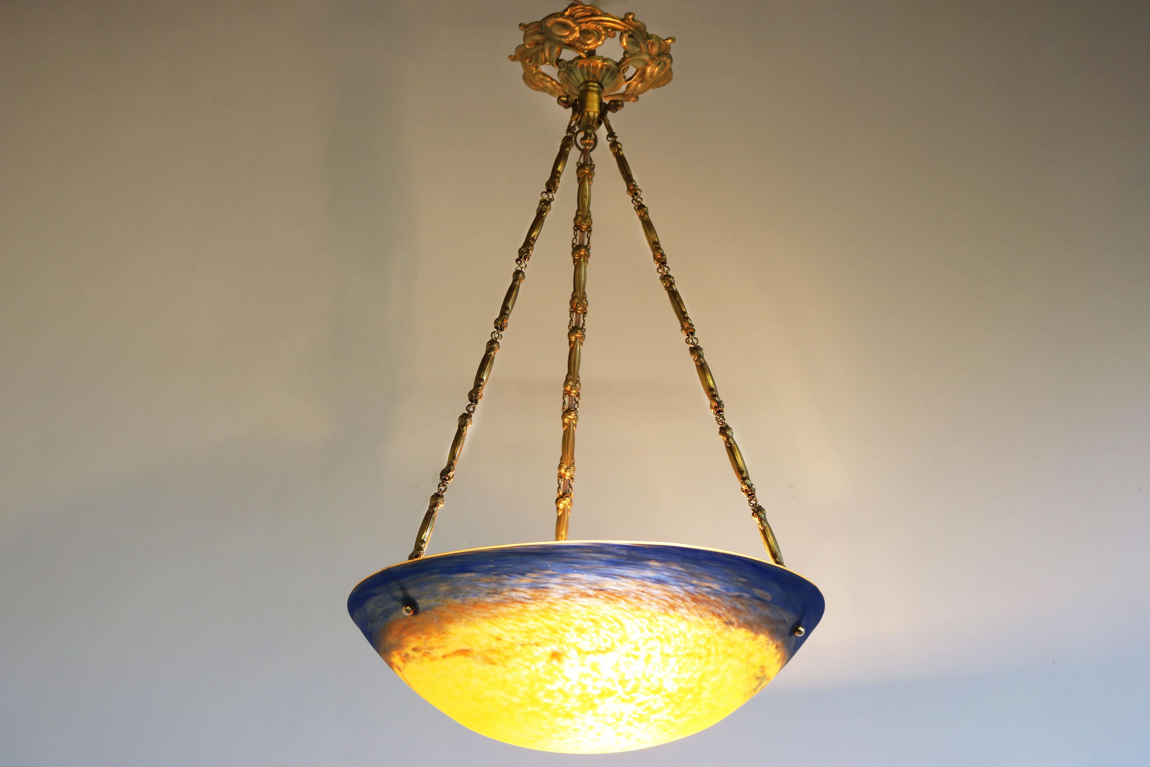 Simply stunning ! This French Art Deco / Art Nouveau ''Pâte de Verre'' chandelier by David Gueron Degue 1910-1920. Gorgeous model with the rare yellow/orange/blue colors & signed with degue. Matching bronze canopy with amazing floral details. This