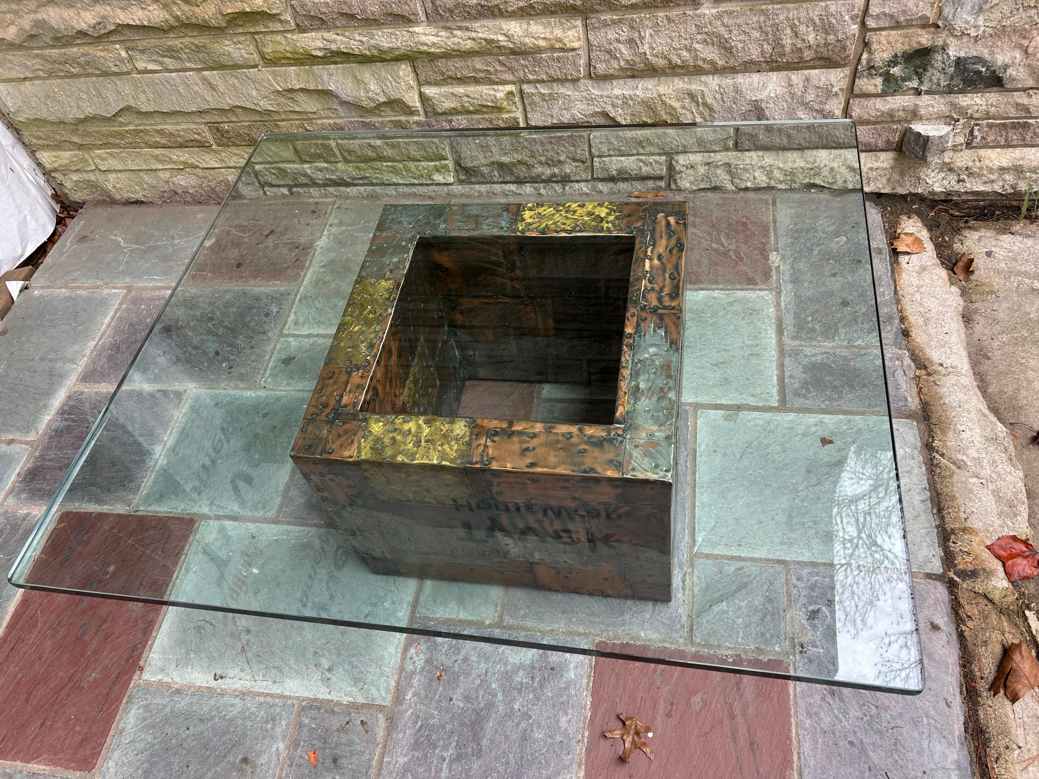 Magnifique table basse en patchwork de l'emblématique Paul Evans. Cette table est composée de cuivre, de bronze et d'acier soudés. Evans a conçu cette table pour Directional dans les années 1970. Cette table a conservé son plateau en verre d'origine