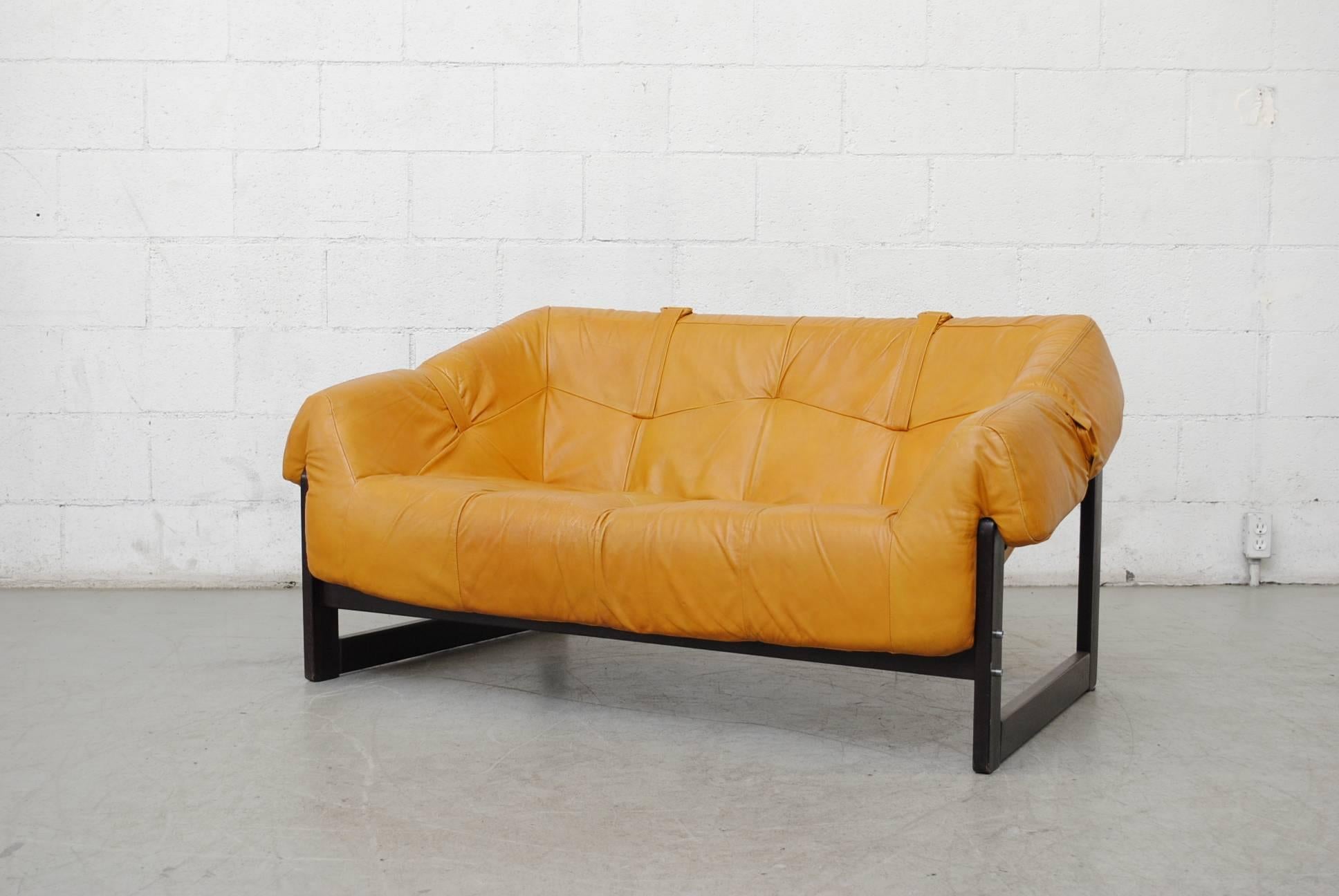 Beautiful caramel leather loveseat by Percival Lafer with leather strap support and original wood frame. Good original condition.