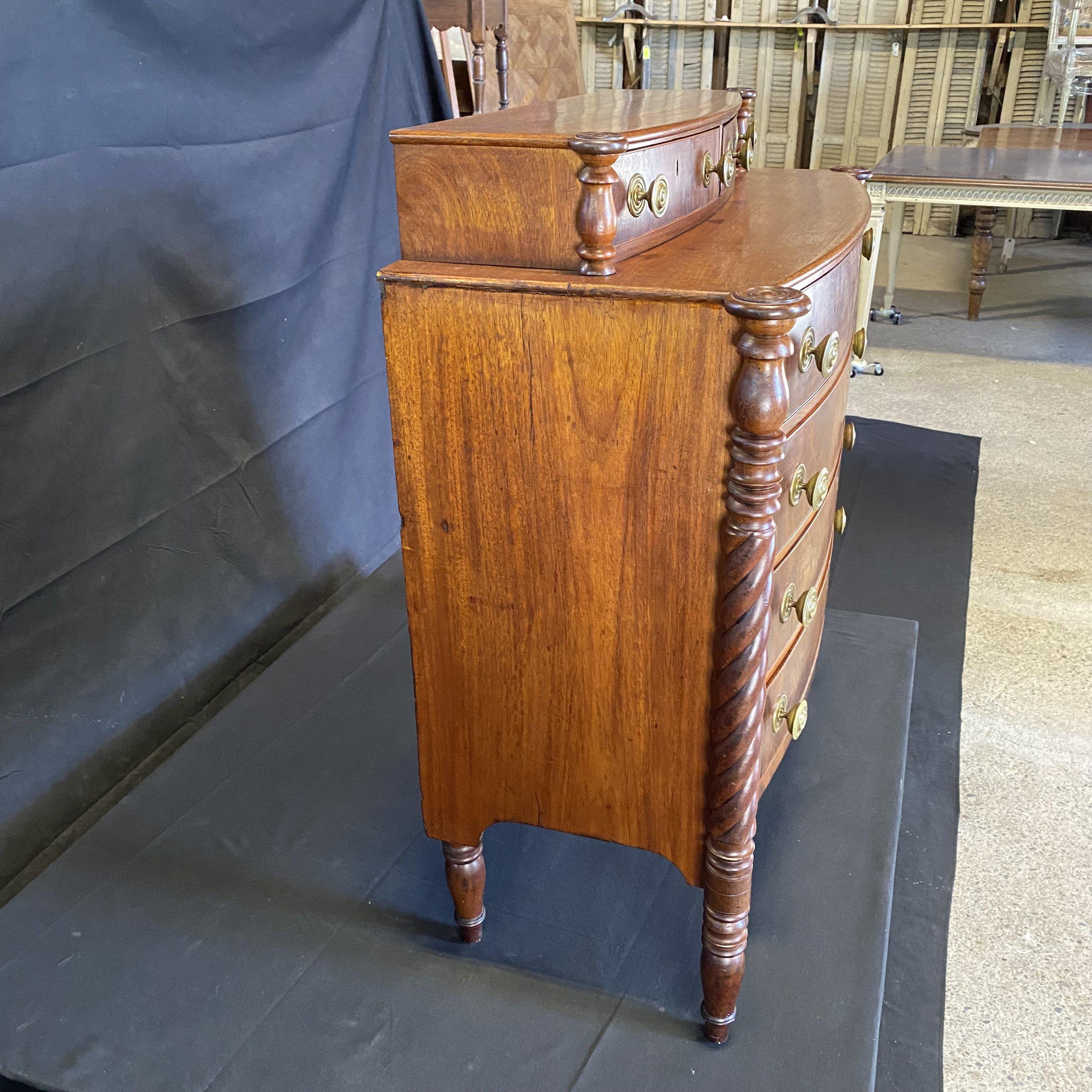 Lovely Sheraton transitional chest of drawers, Maine origin, mahogany, circa 1830-1850. Full barley twist baluster columns on the front, supported by four turned feet. The ornate Sheraton knobs are of stamped brass and original. The wide plank back