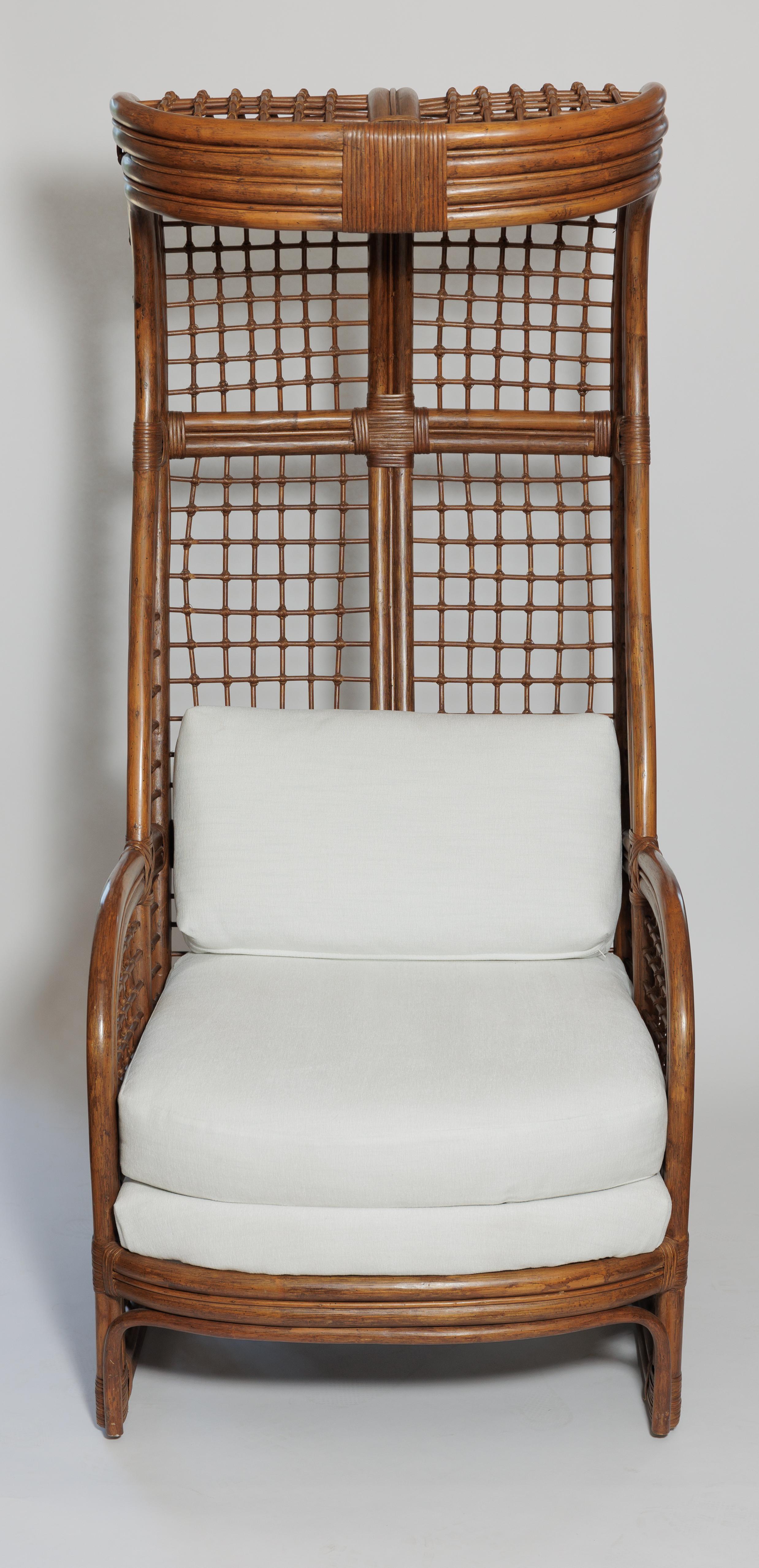 A statement pair of rattan chairs with canopy and newly unholstered cushions.