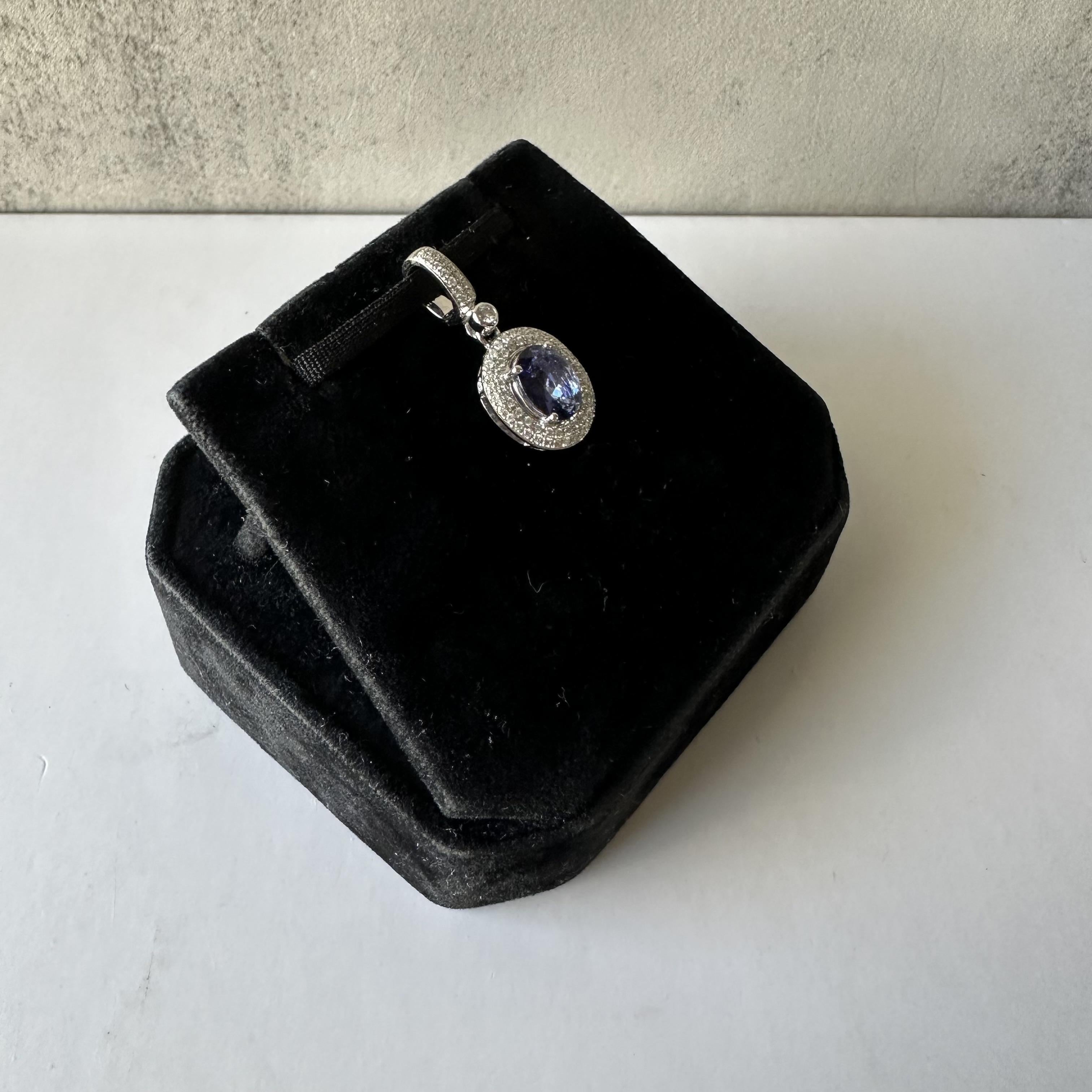 Élevez votre élégance avec cet exquis pendentif en or blanc 14k orné de tanzanites et de diamants. Doté d'une tanzanite bleue ovale de 1,15 carat, ce pendentif séduit par sa teinte vibrante. La tanzanite est entourée de 0,35 carats de diamants