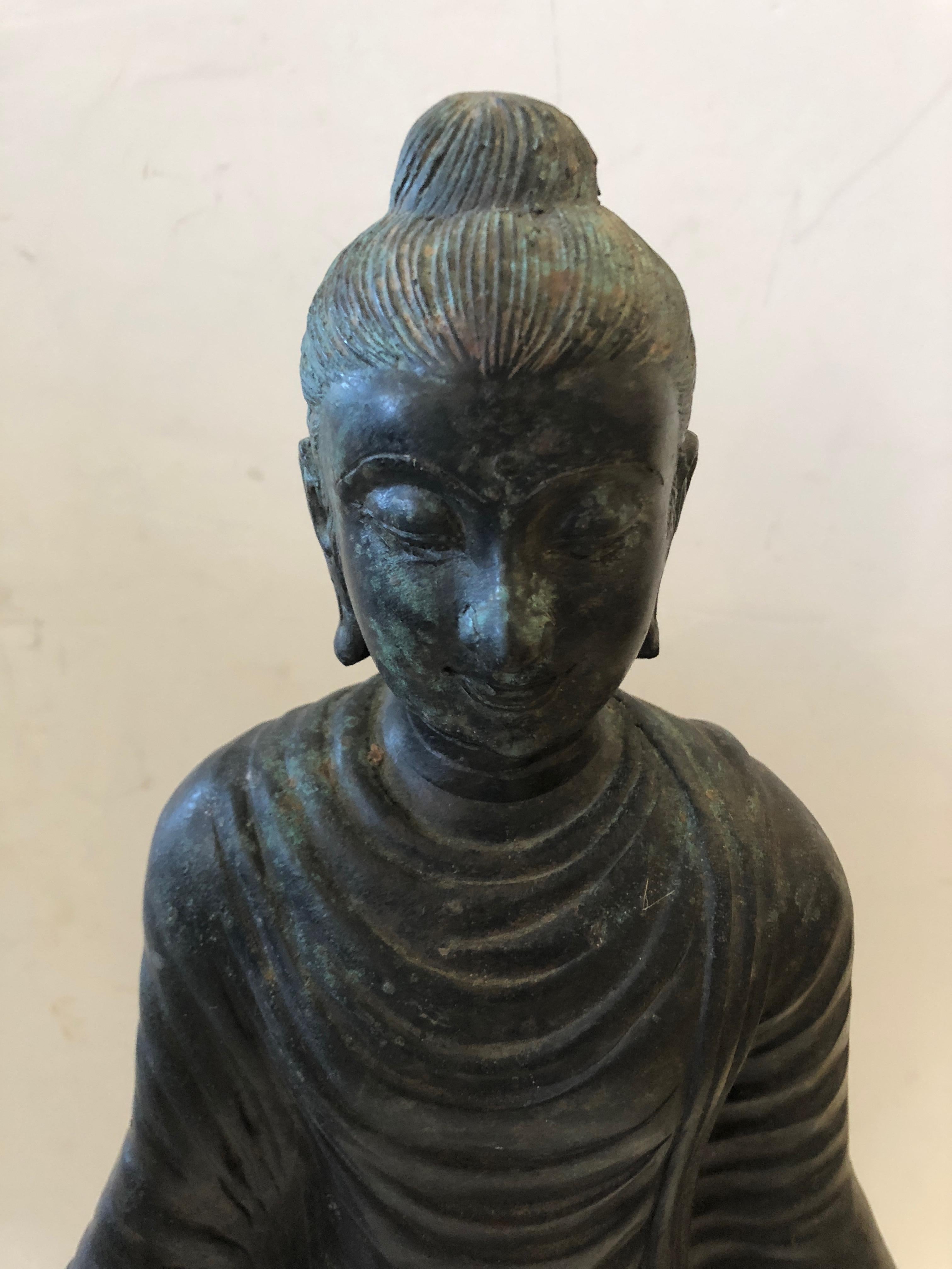 A beautiful medium sized bronze Buddha with some natural verdigris patina. The gestural hands are beautifully placed, and the meticulous detailing is impressive.