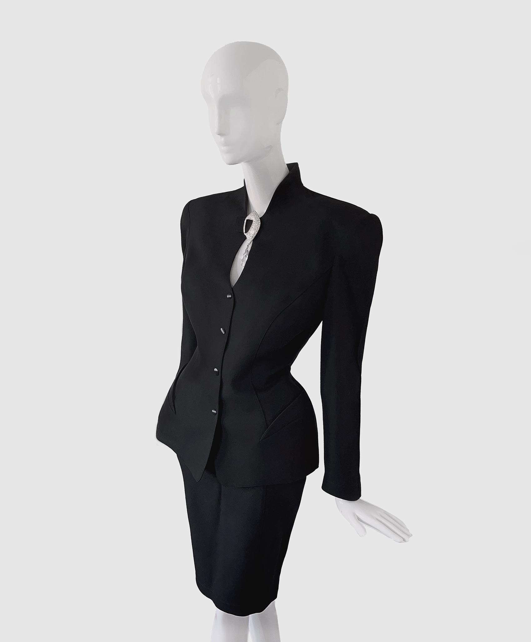 
Extremely rare and glamorous Thierry Mugler Ensemble. A stunning creation of the one and only Manfred Thierry Mugler, early 90s Collection.
Gorgeous super feminine blazer jacket with fitted waist, strong shoulders and amazing high collar with