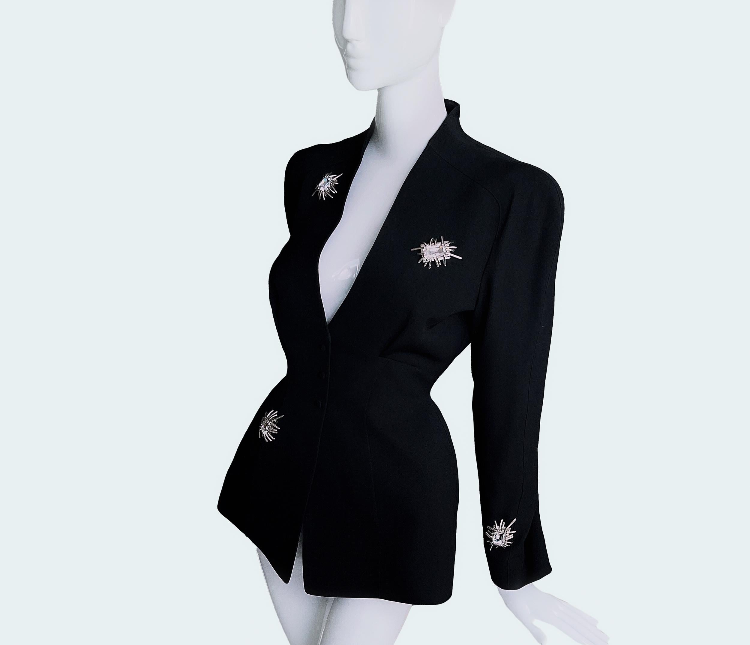 
Extremely rare stunning Thierry Mugler creation, assuming FW 1992 Collection.
Fabulously tailored jacket with fitted feminine sculptural shape and deep V-neck. Highlights are amazing big silver metal details with spider-like features and beautiful