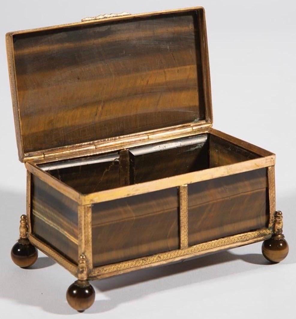 Gorgeous bronze mounted tiger's eye box with beveled lid, and tiger's eye ball feet.


  